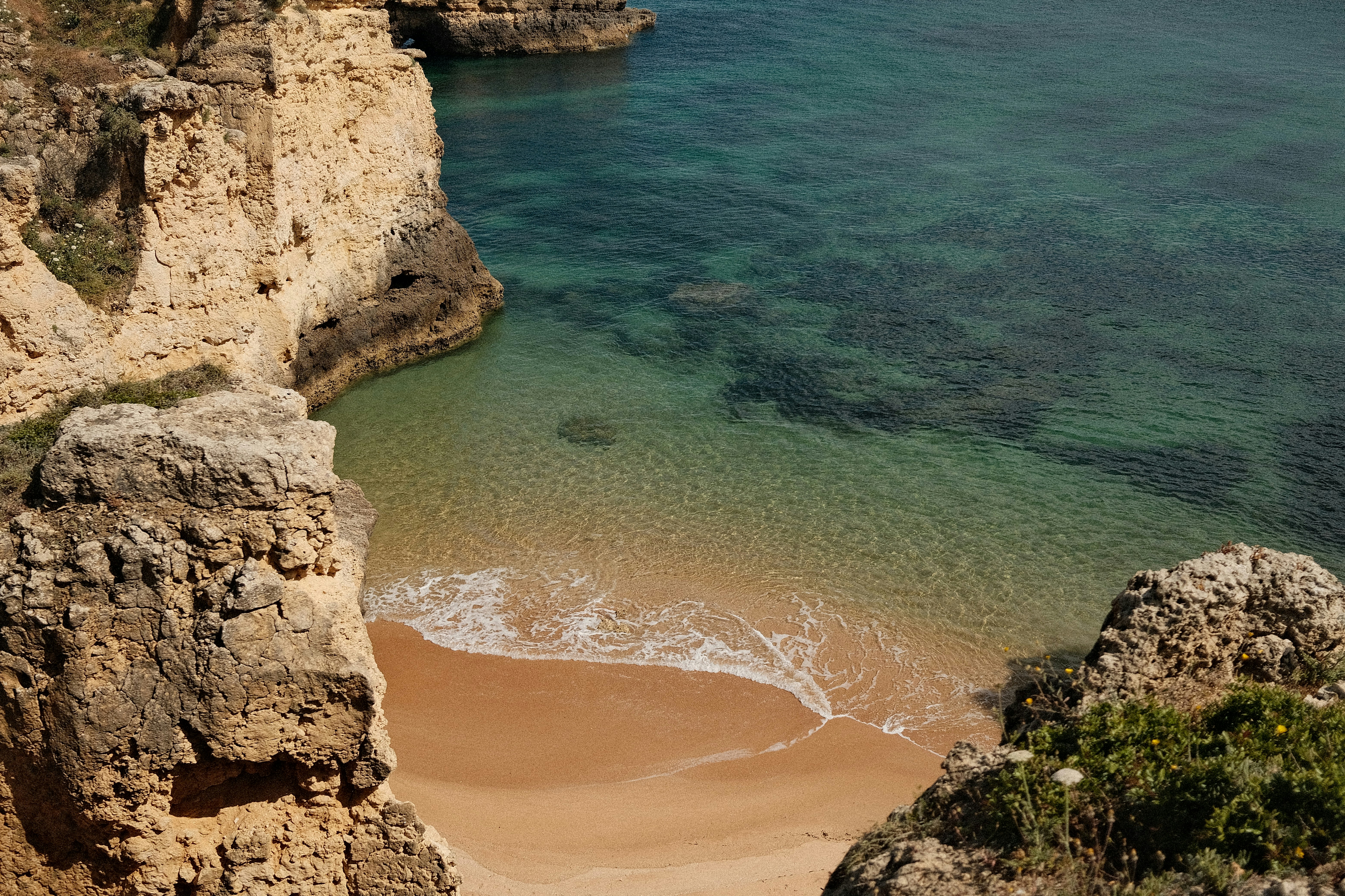 Secluded sandy cove with clear turquoise water and rocky cliffs. - 相关推荐