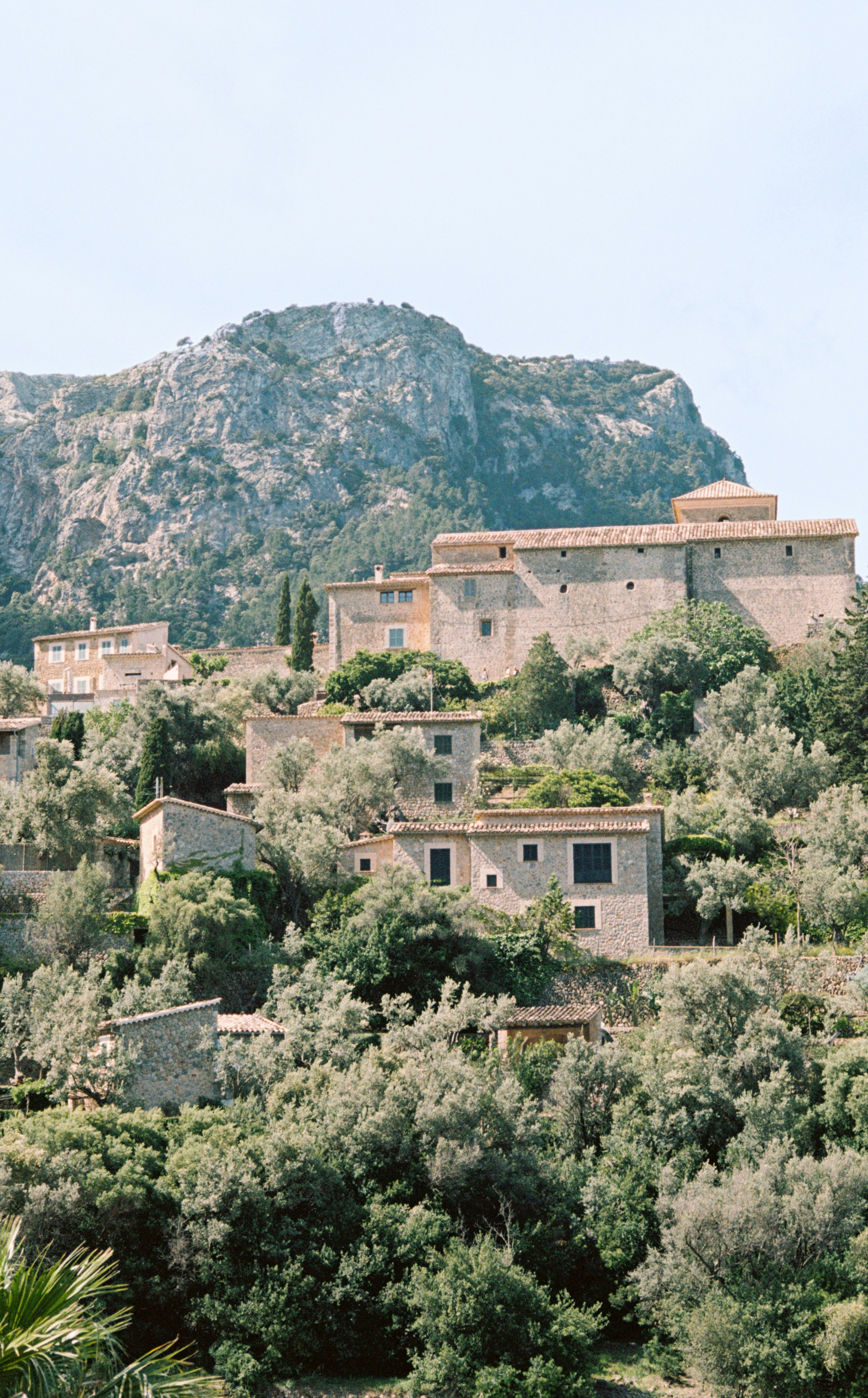 Stone buildings nestled on a lush, green hillside.