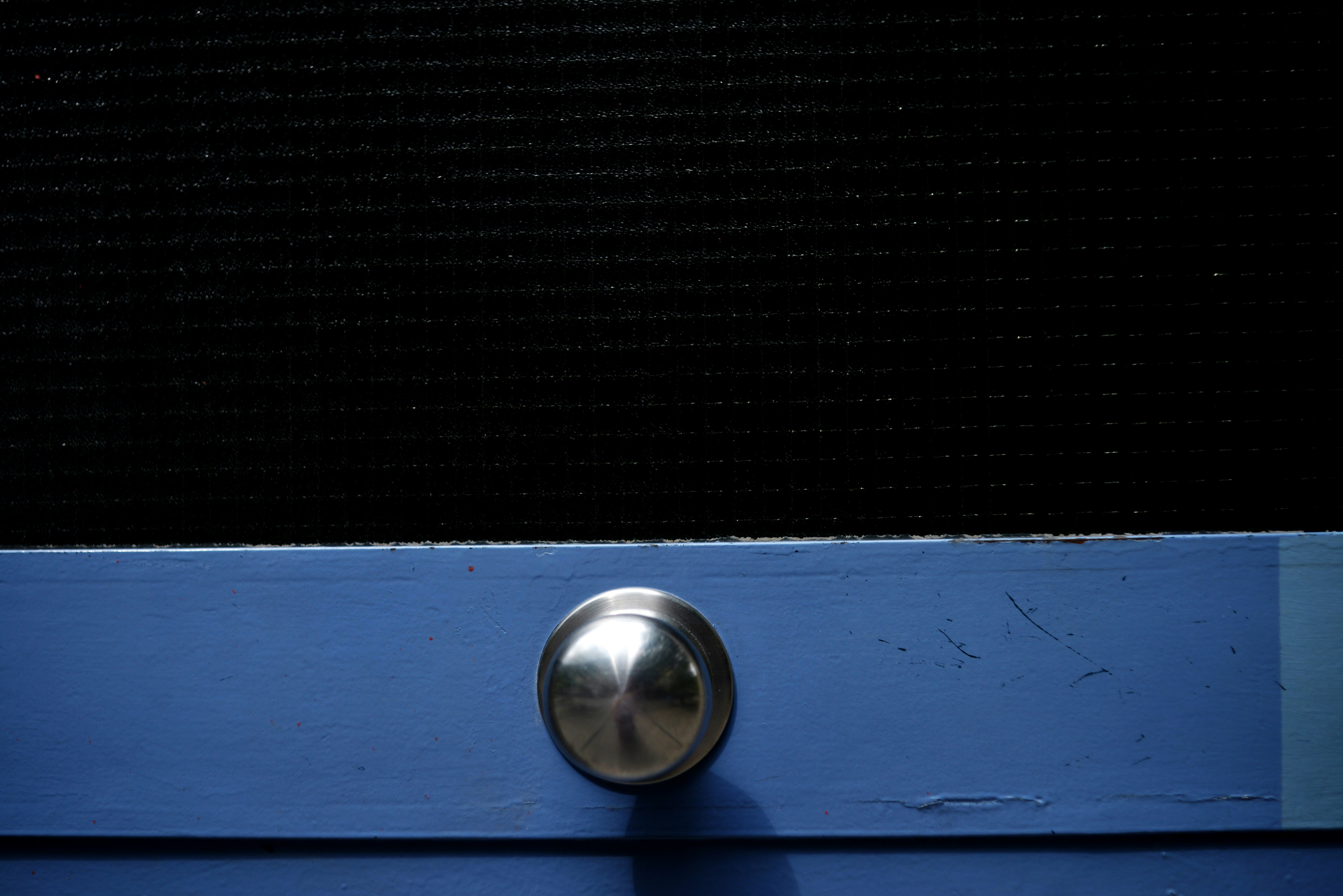 Un bouton argenté sur une surface bleue
