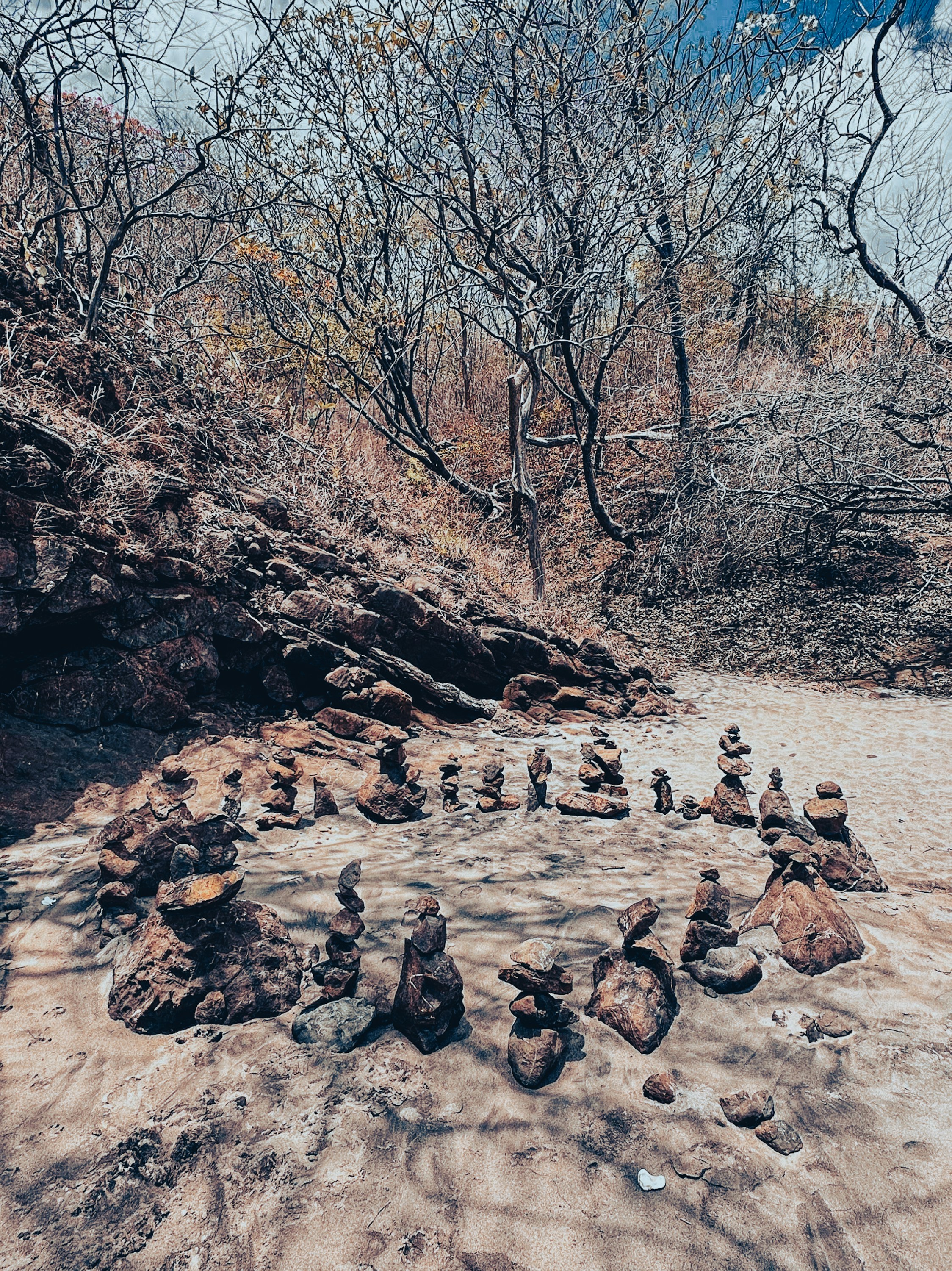 Stacked rocks arranged in a circle on sandy ground