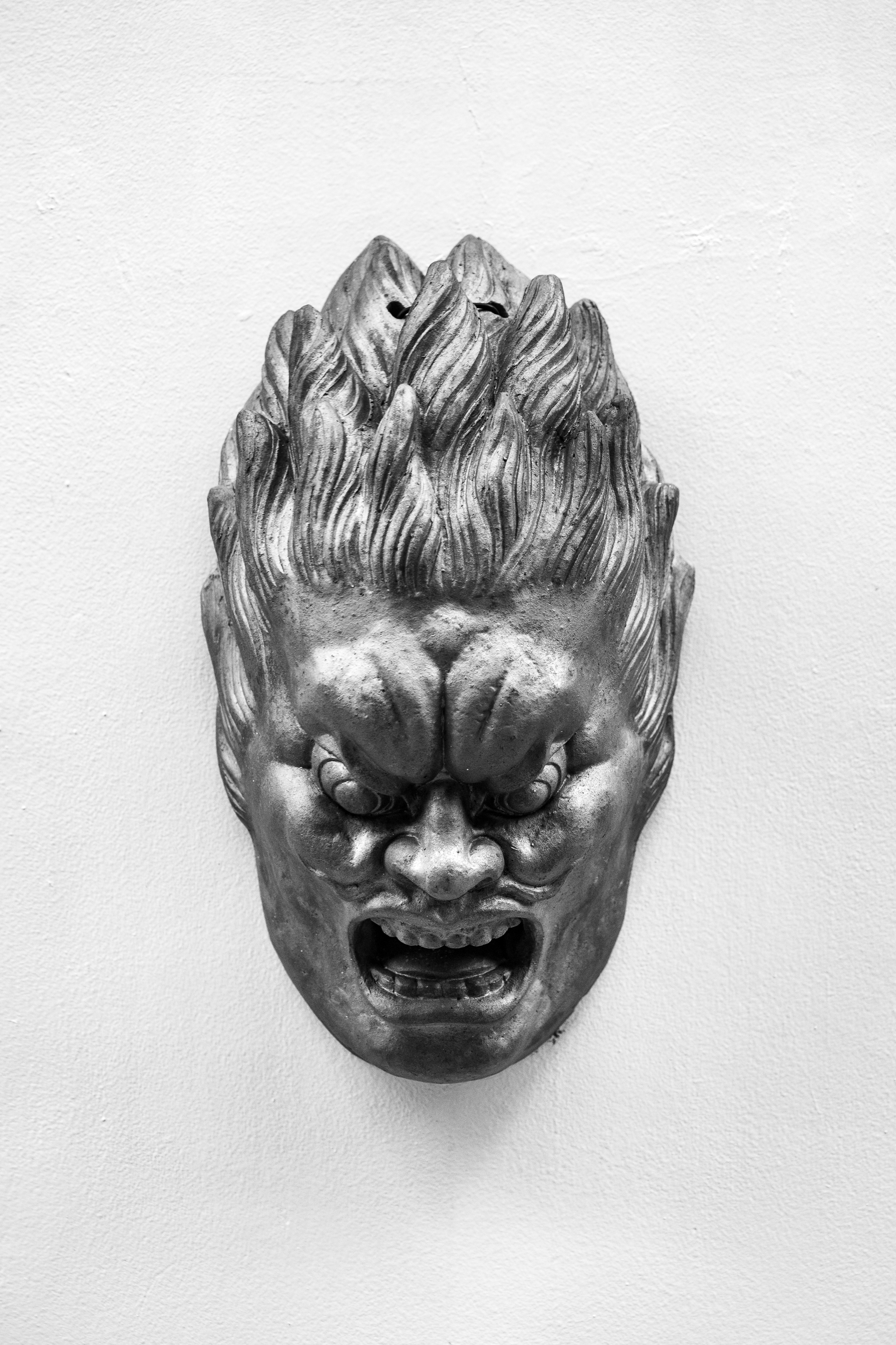 A metal mask with a fierce, angry expression.