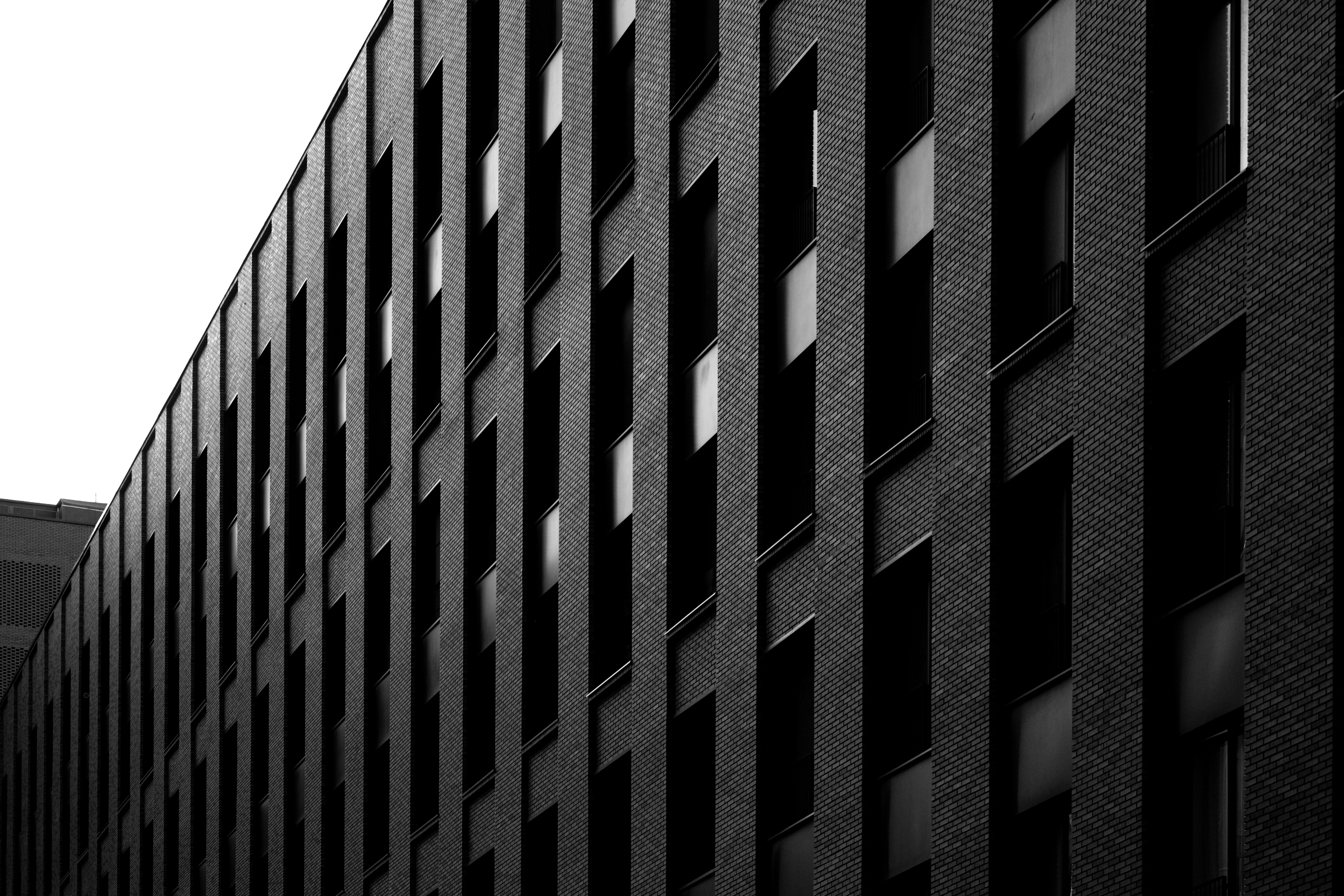 Dark brick building with repetitive windows in a grid pattern.