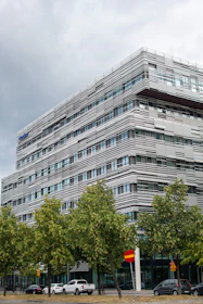 Modern office building with trees and cars on street