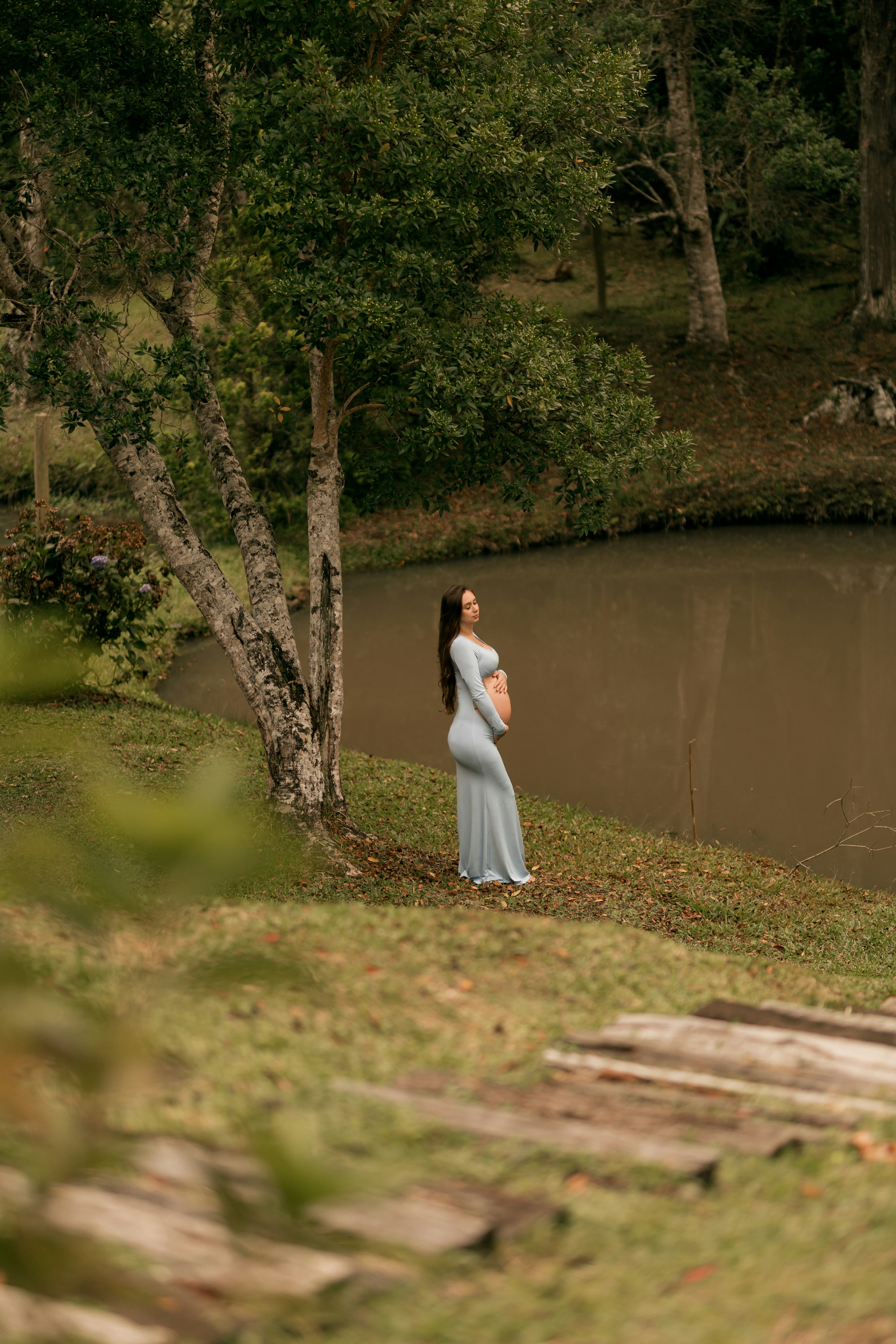 湖畔で水色のドレスを着た妊婦