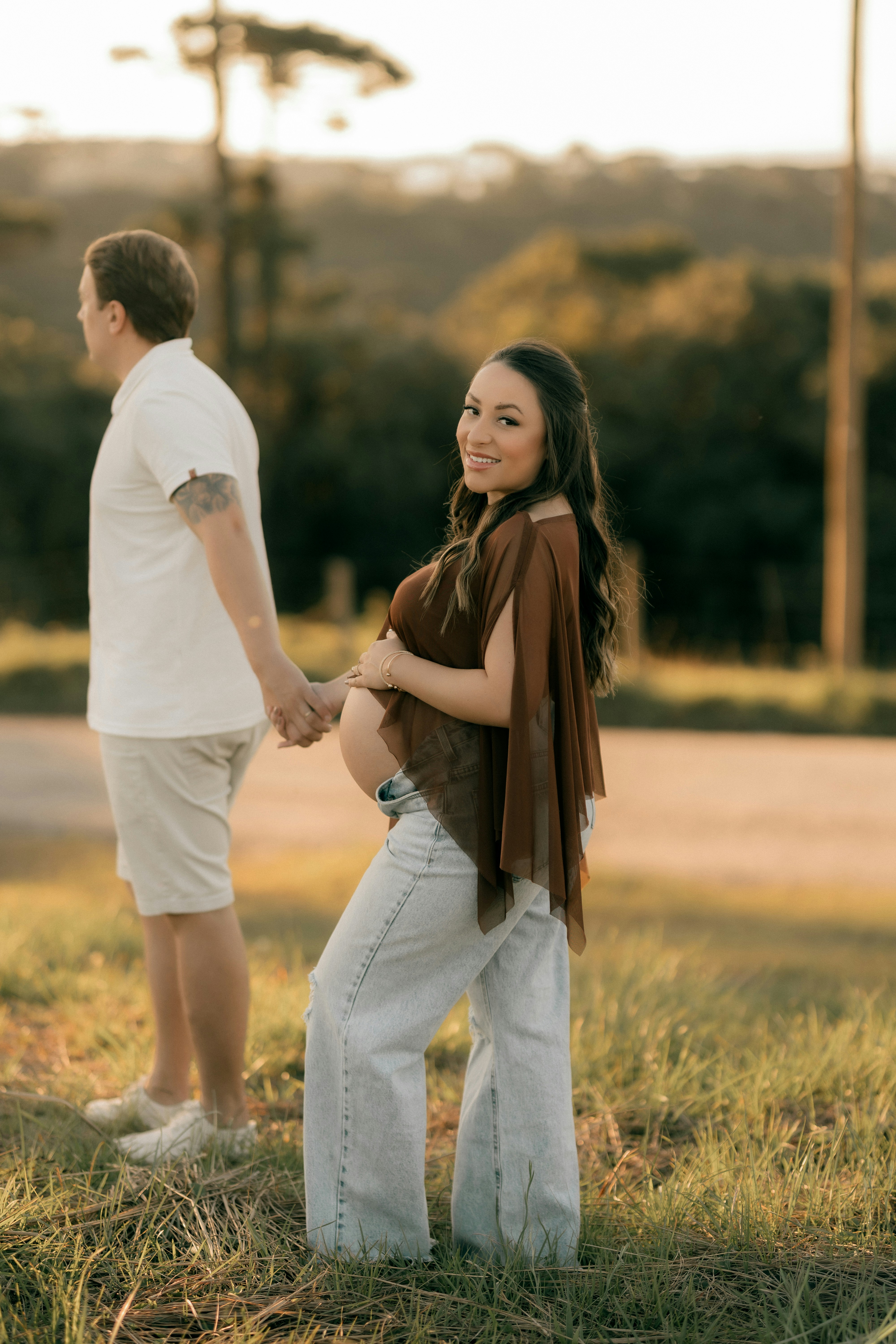 Pregnant woman and man holding hands outdoors
