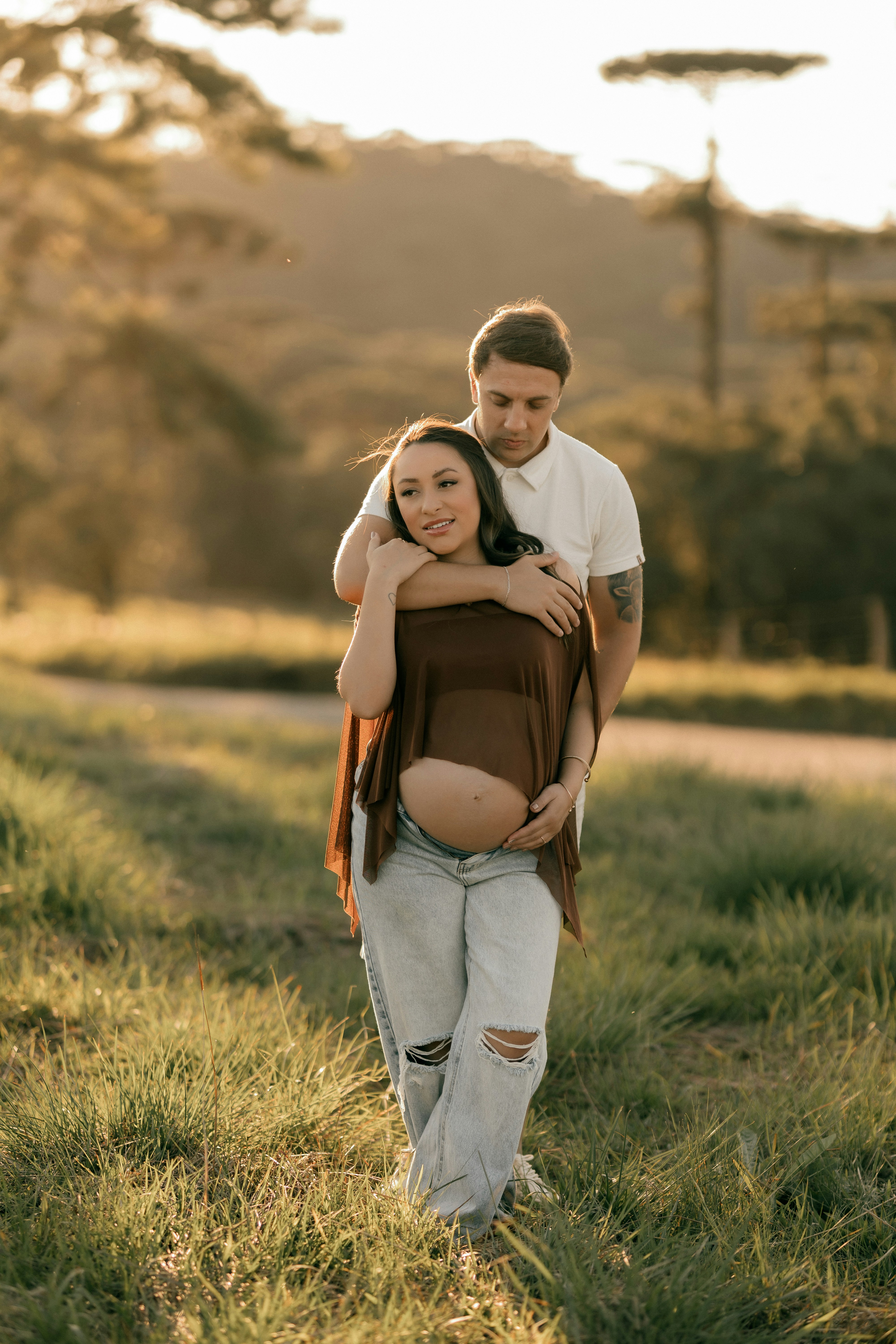 夕暮れ時に屋外で抱き合う妊婦のカップル