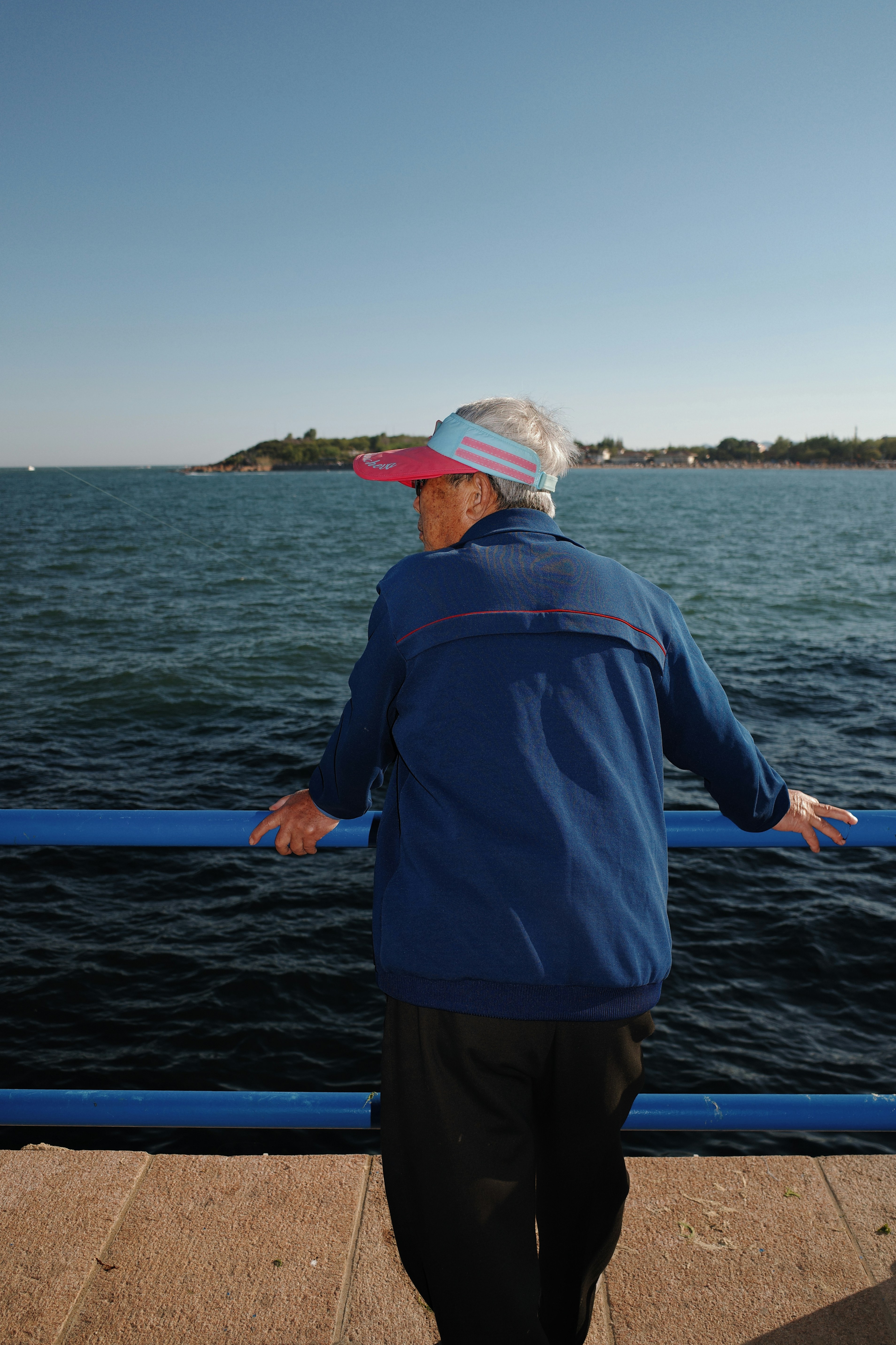 Elderly person looking out at the ocean