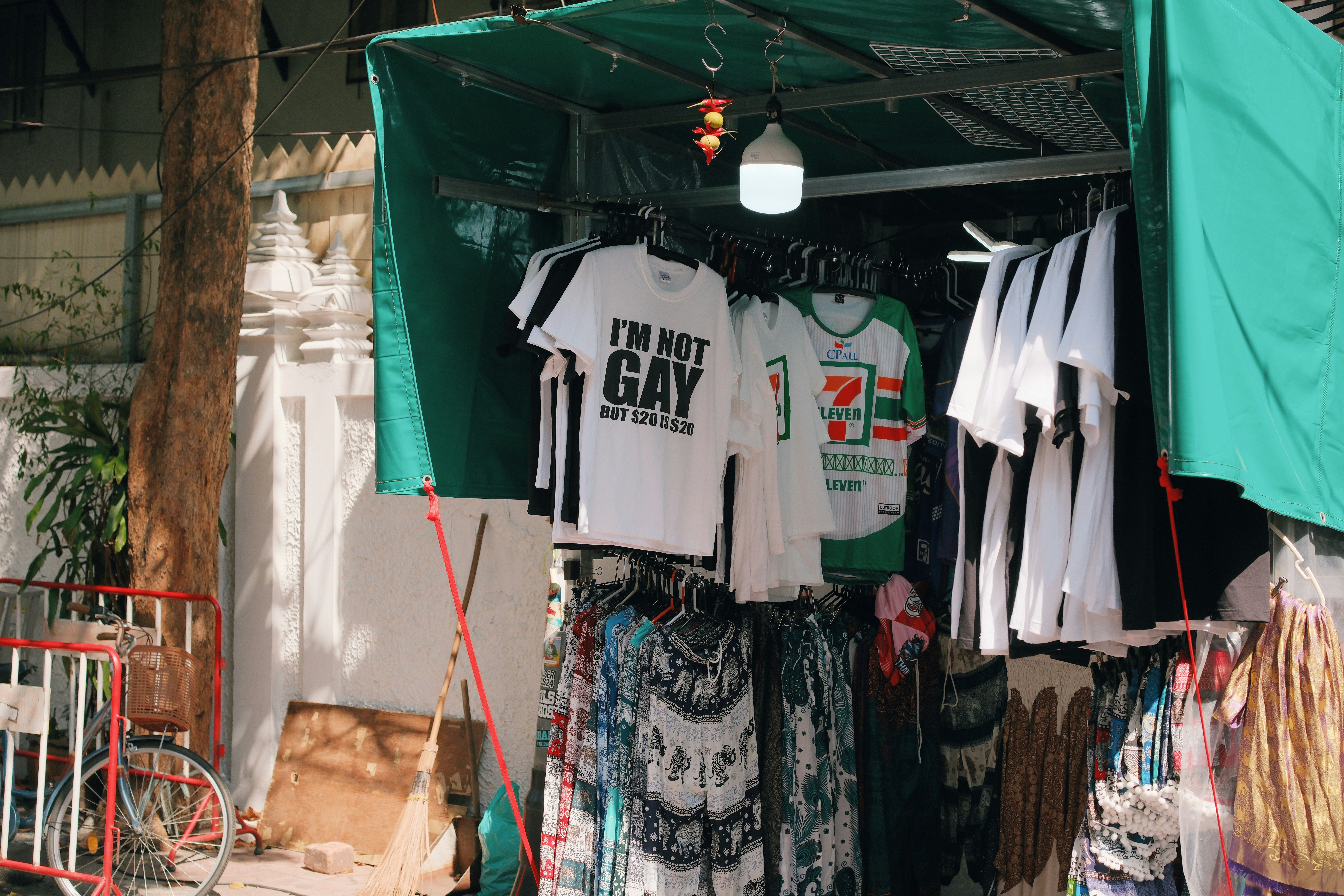 T-shirts and clothing displayed at an outdoor market stall.