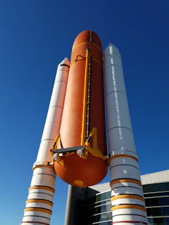 A towering rocket stands against a clear blue sky