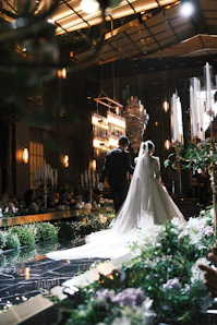 Bride and groom walk down a lavishly decorated wedding aisle.