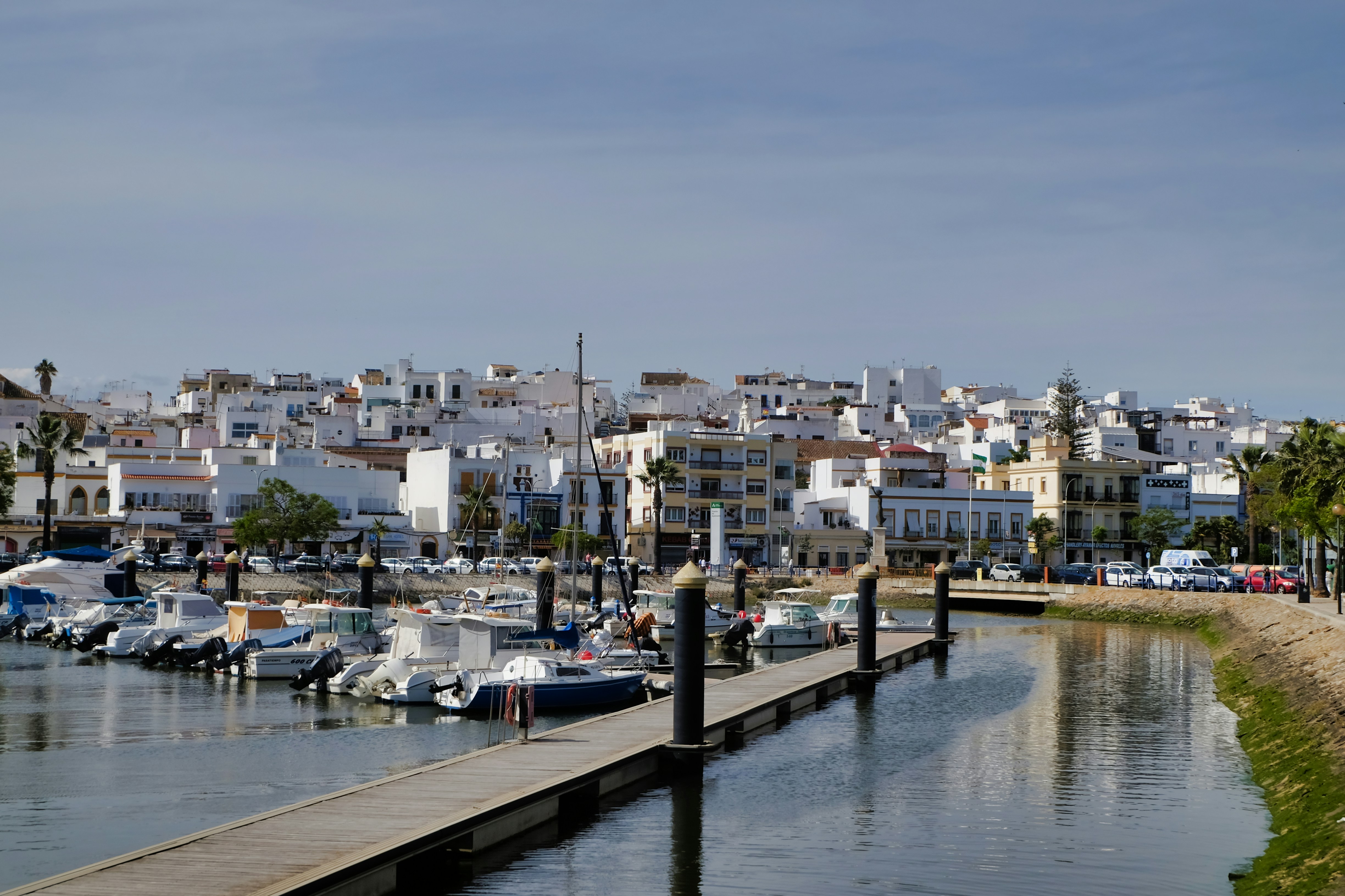 Des bateaux amarrés dans une marina avec des bâtiments blancs au-delà