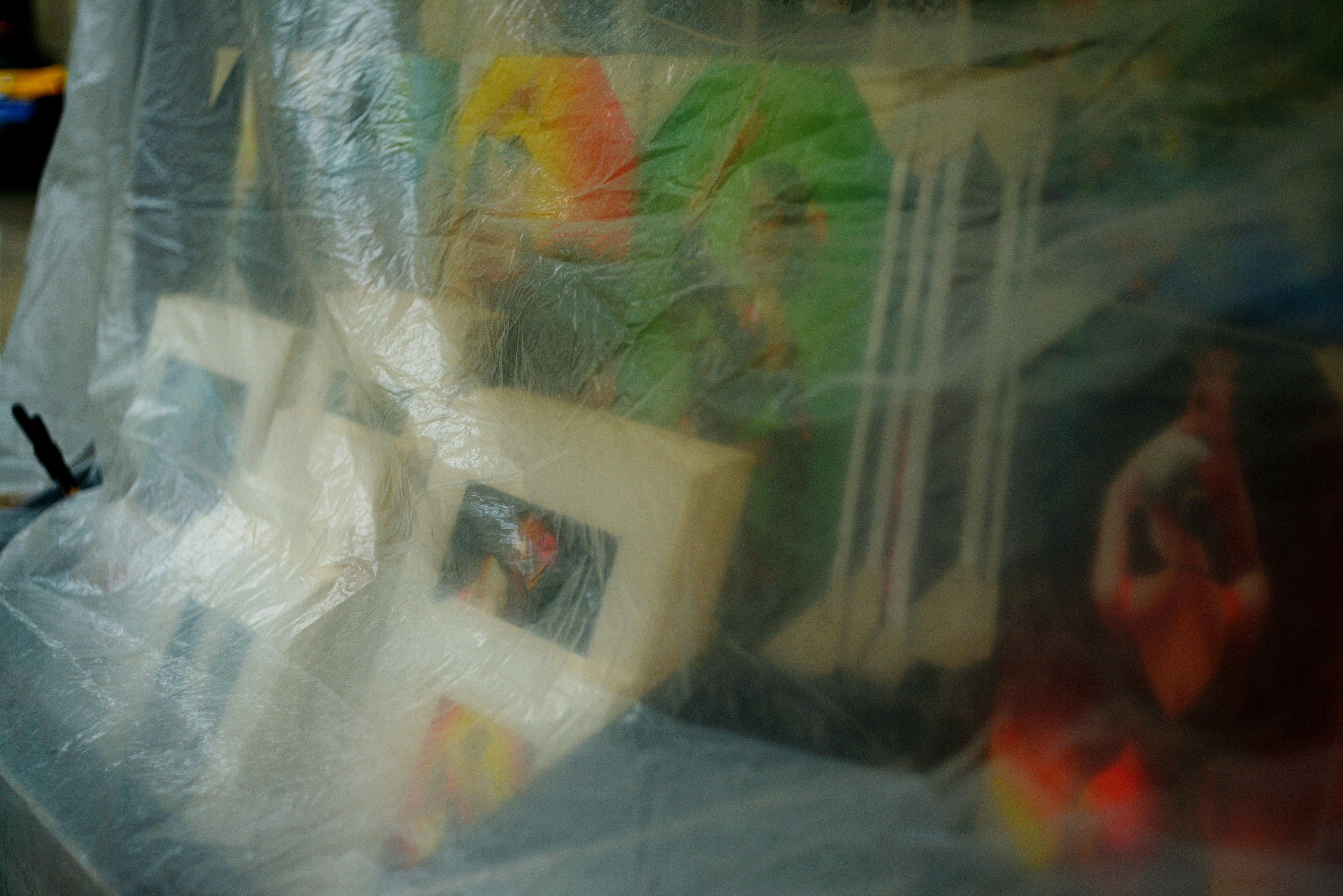 Several framed pictures covered in plastic wrap