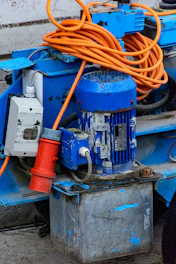 Blue industrial motor with orange cable and red plug