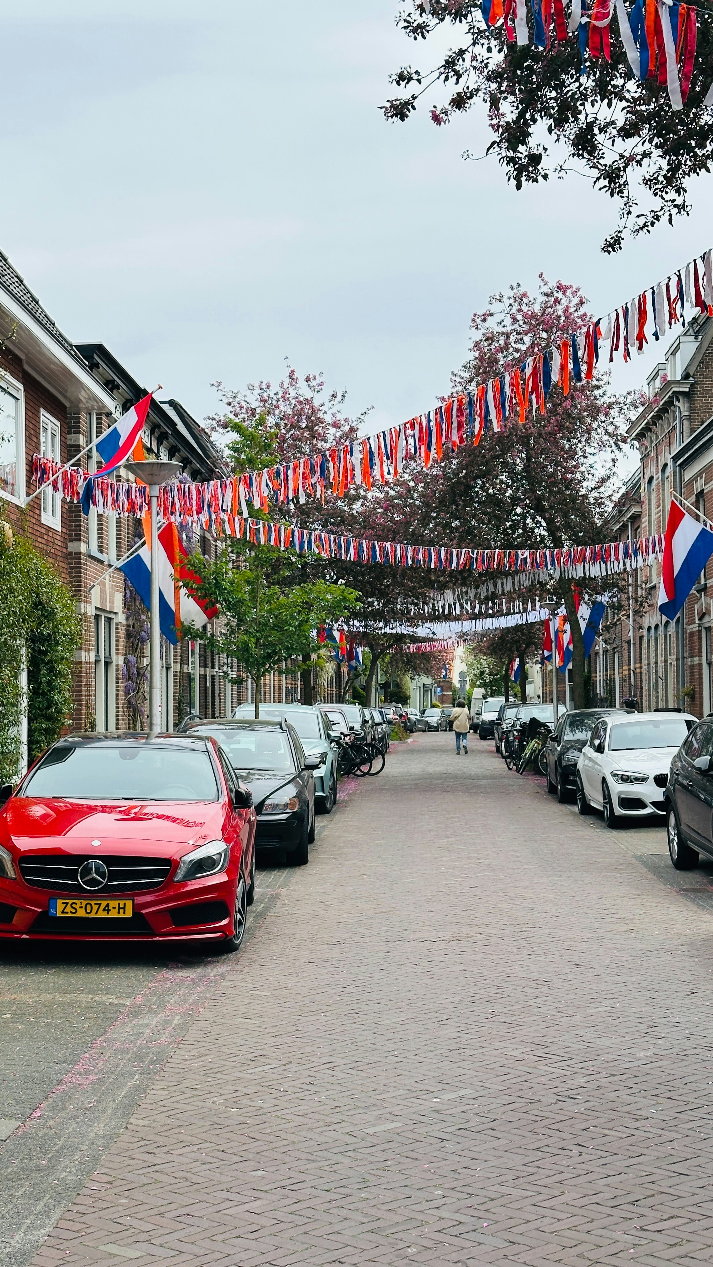 Street decorated with flags and parked cars