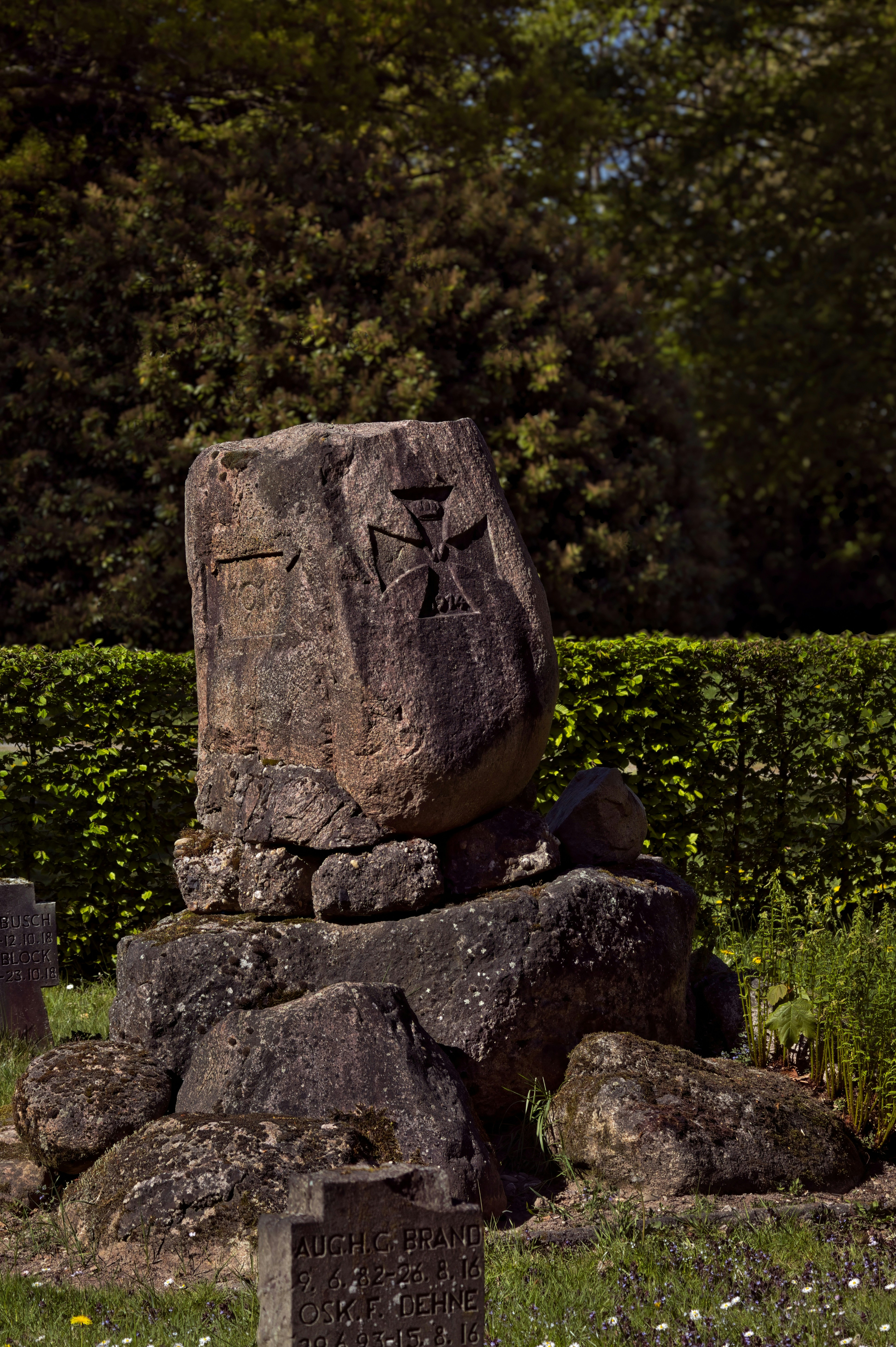 Un monumento de piedra desgastado con una cruz grabada.