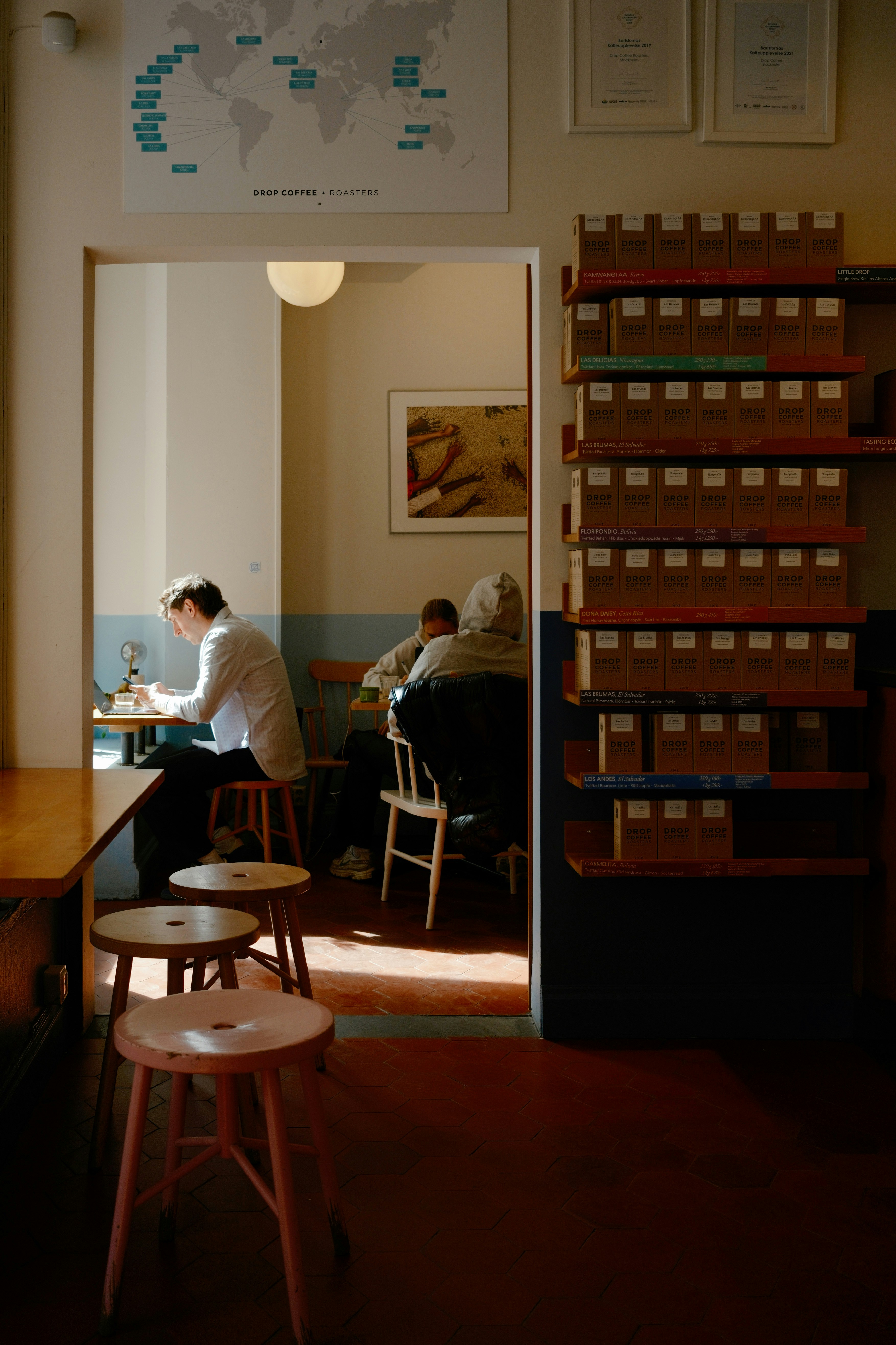 People sit at tables in a sunlit cafe interior