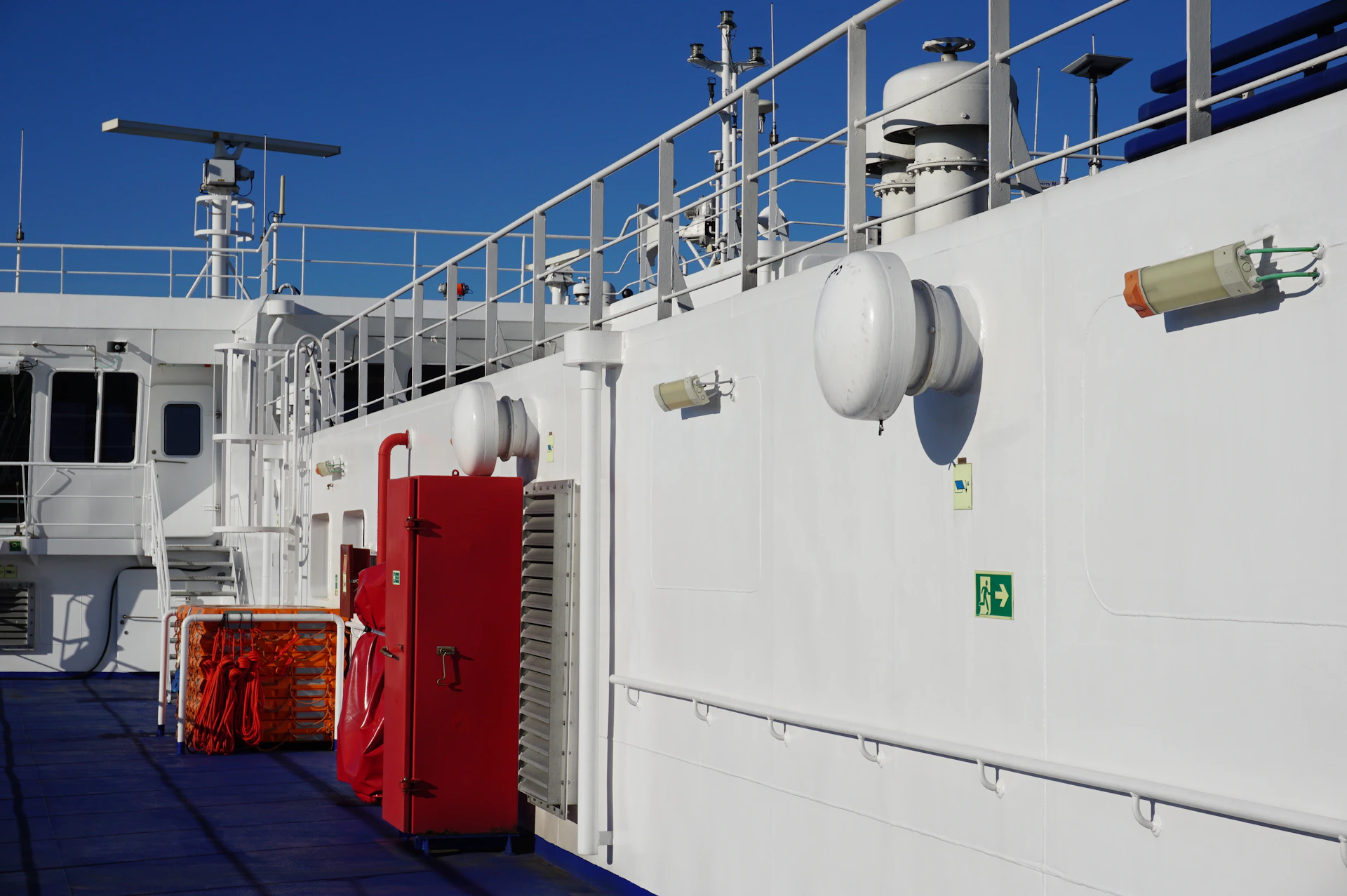 White ship deck with red fire extinguisher cabinet