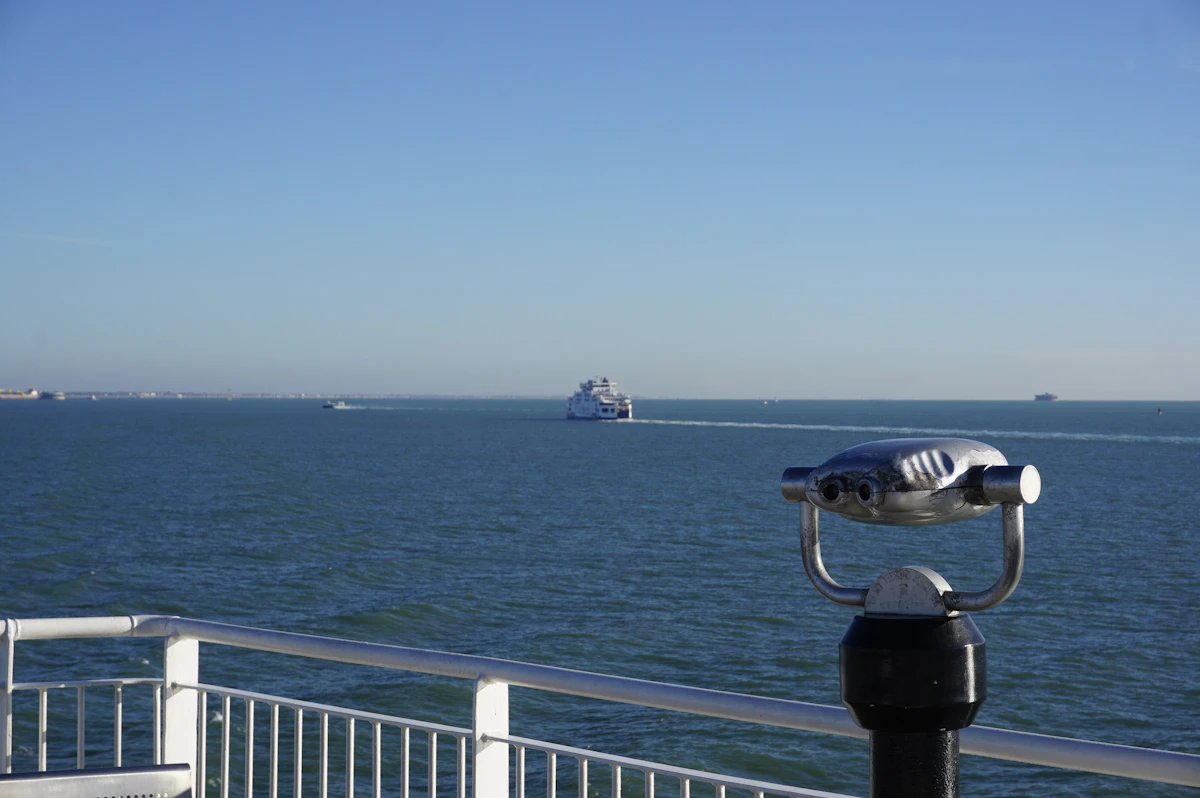 A pair of binoculars on a ferry deck, with the open ocean behind