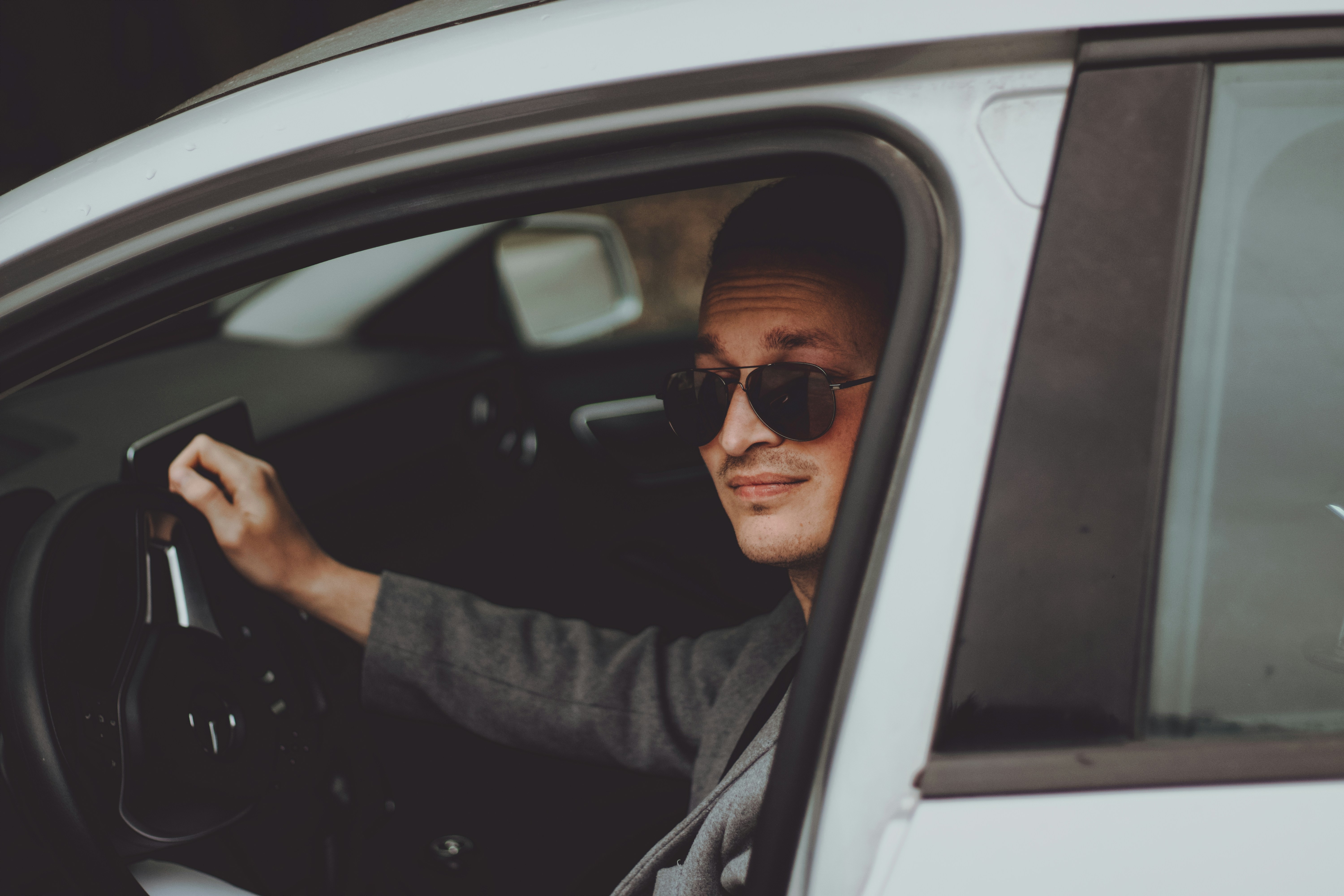 Man wearing sunglasses driving a car