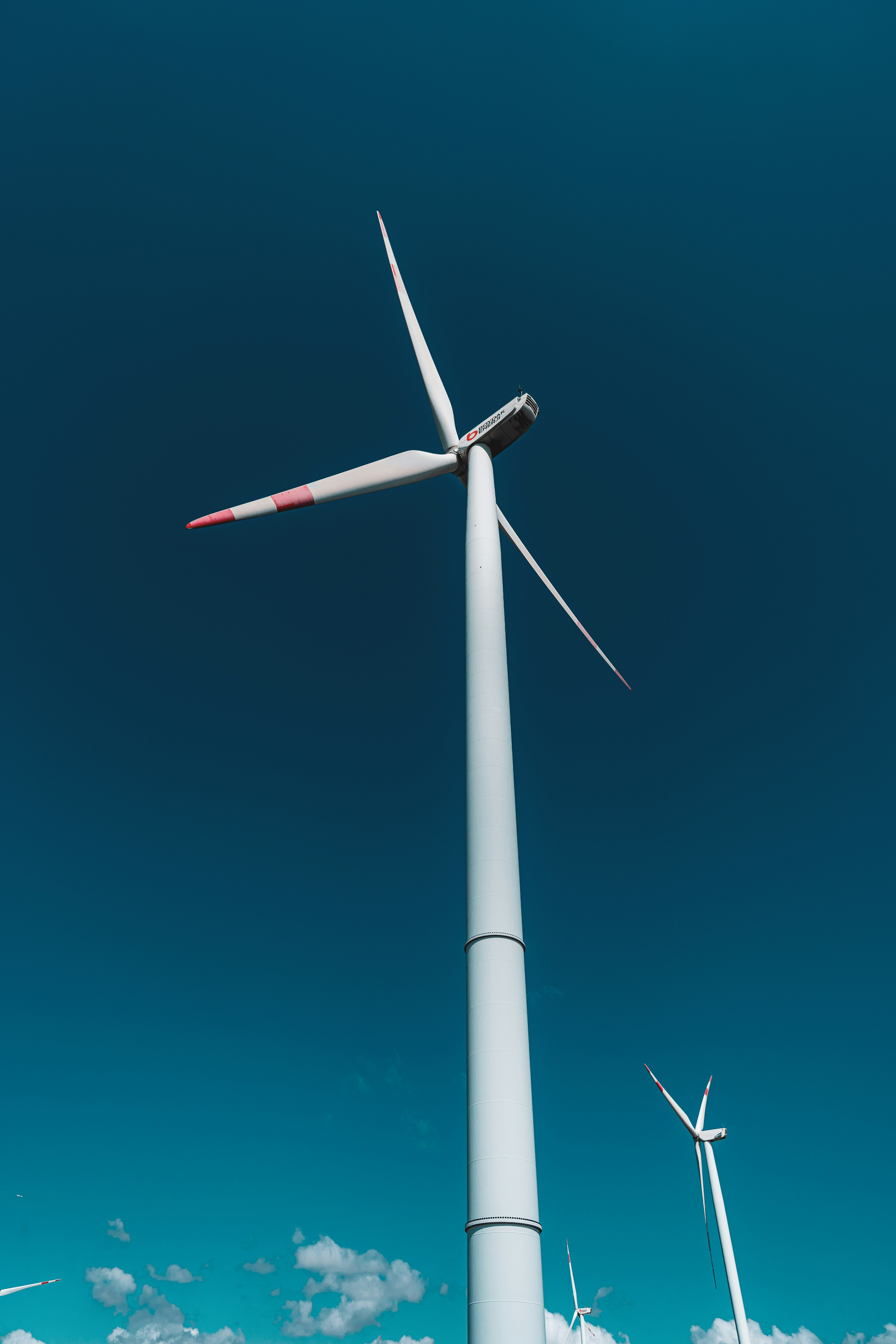Un aerogenerador blanco contra un cielo azul despejado.