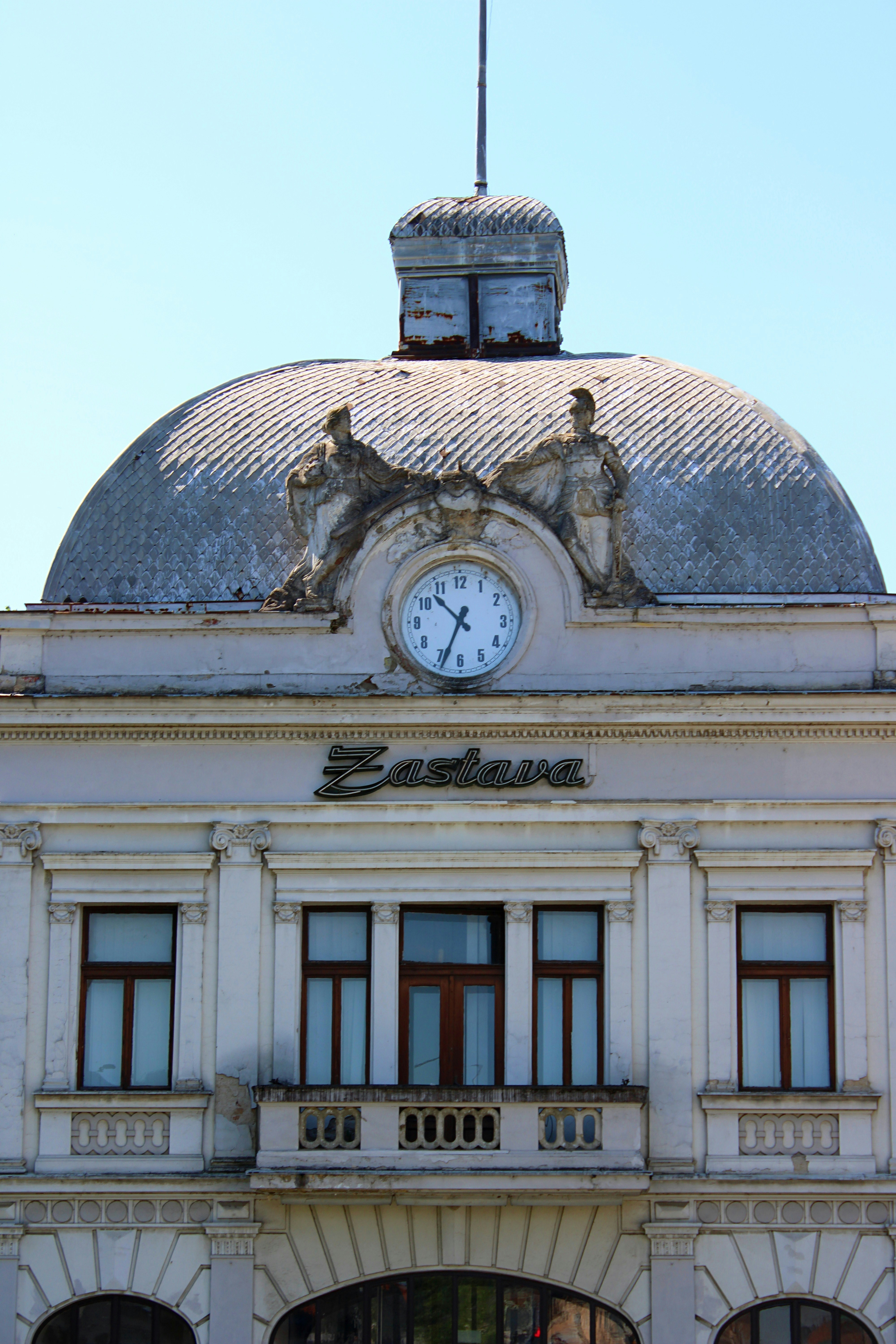 Weathered building featuring a central clock, dome, and