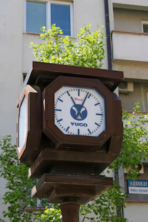 A street clock with yugo and zmin logos.