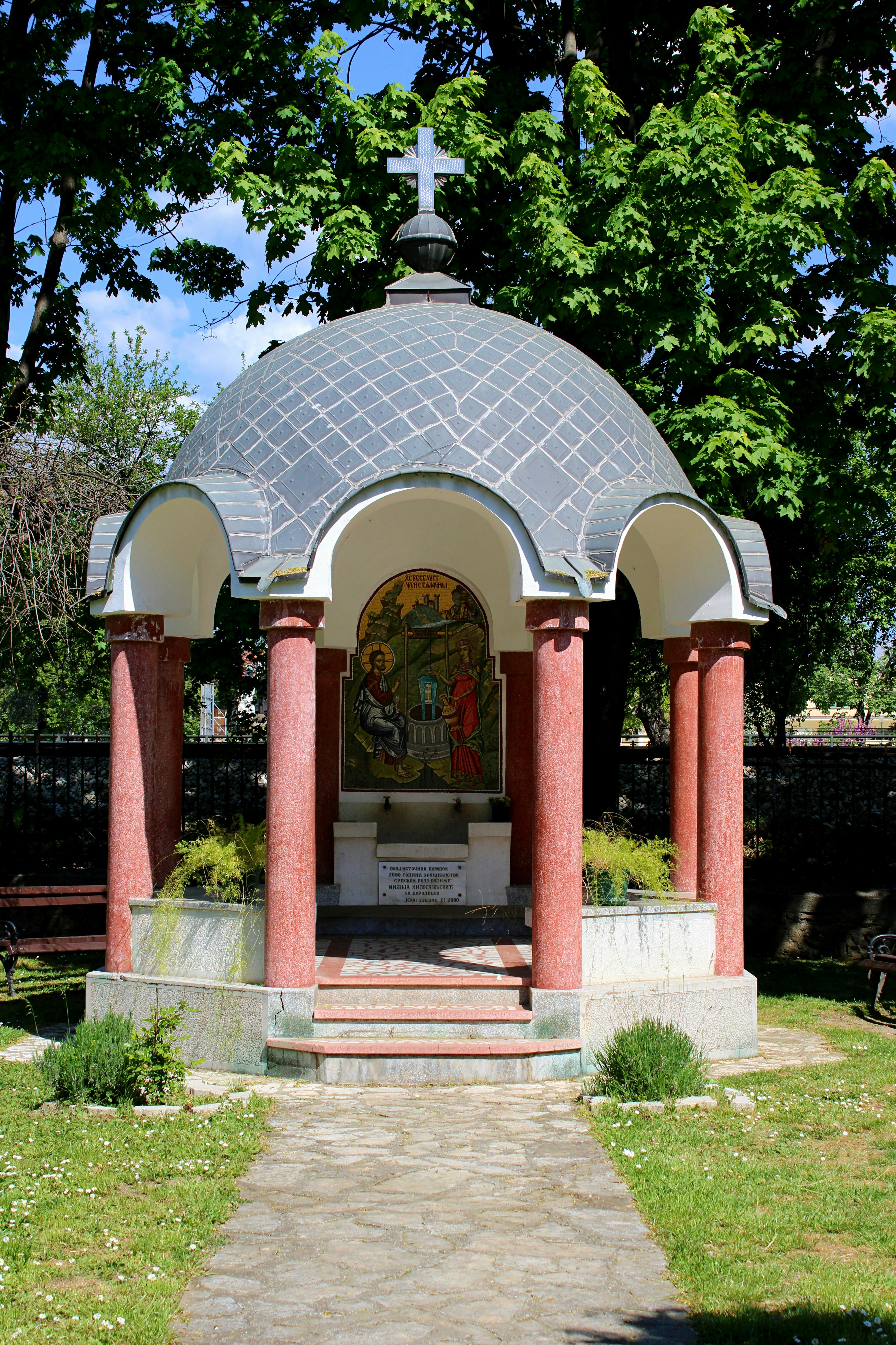 A small domed chapel with red pillars and a mosaic.