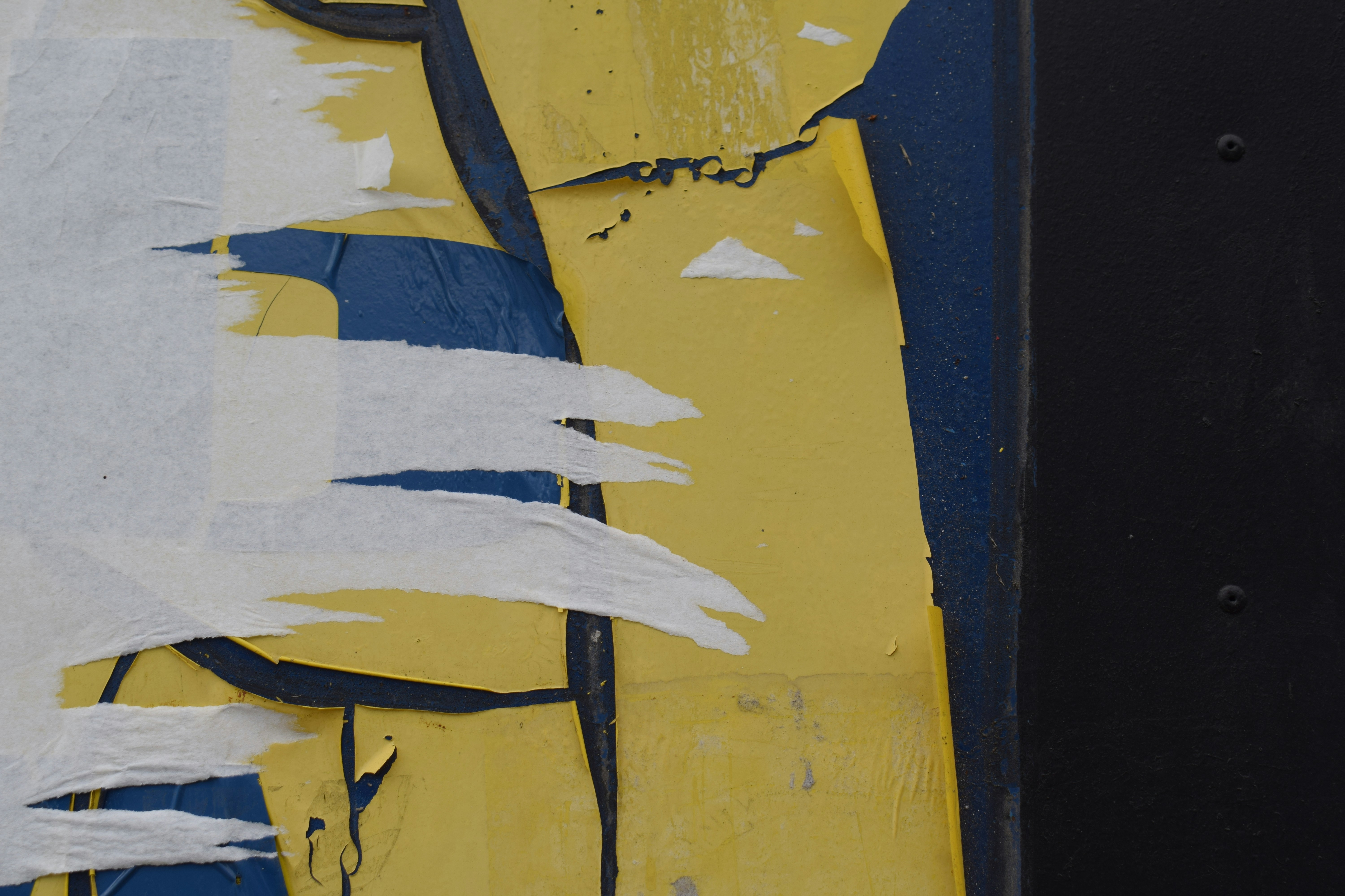 Torn paper layers reveal yellow and blue abstract design