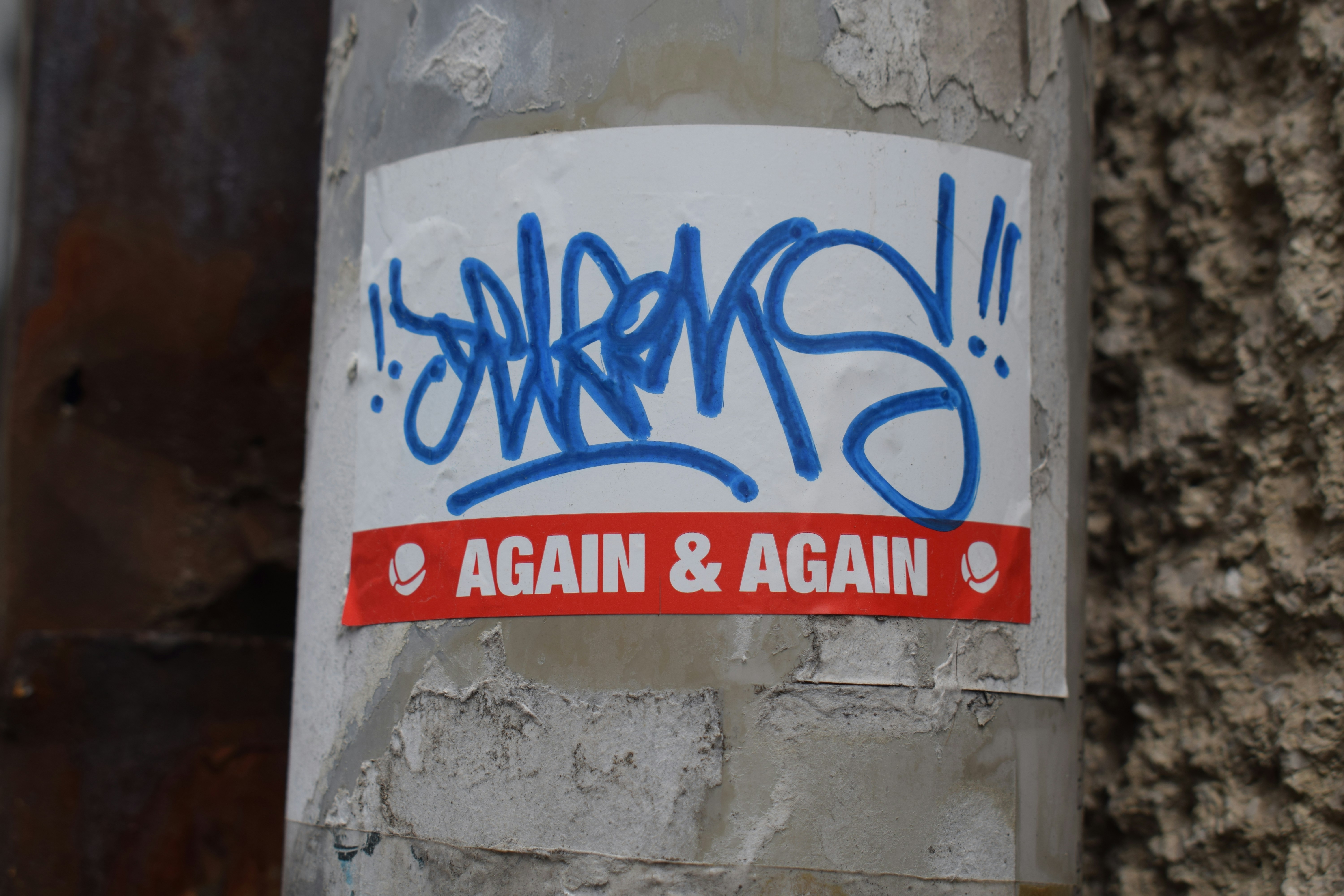 Sticker with blue graffiti and "again & again" text