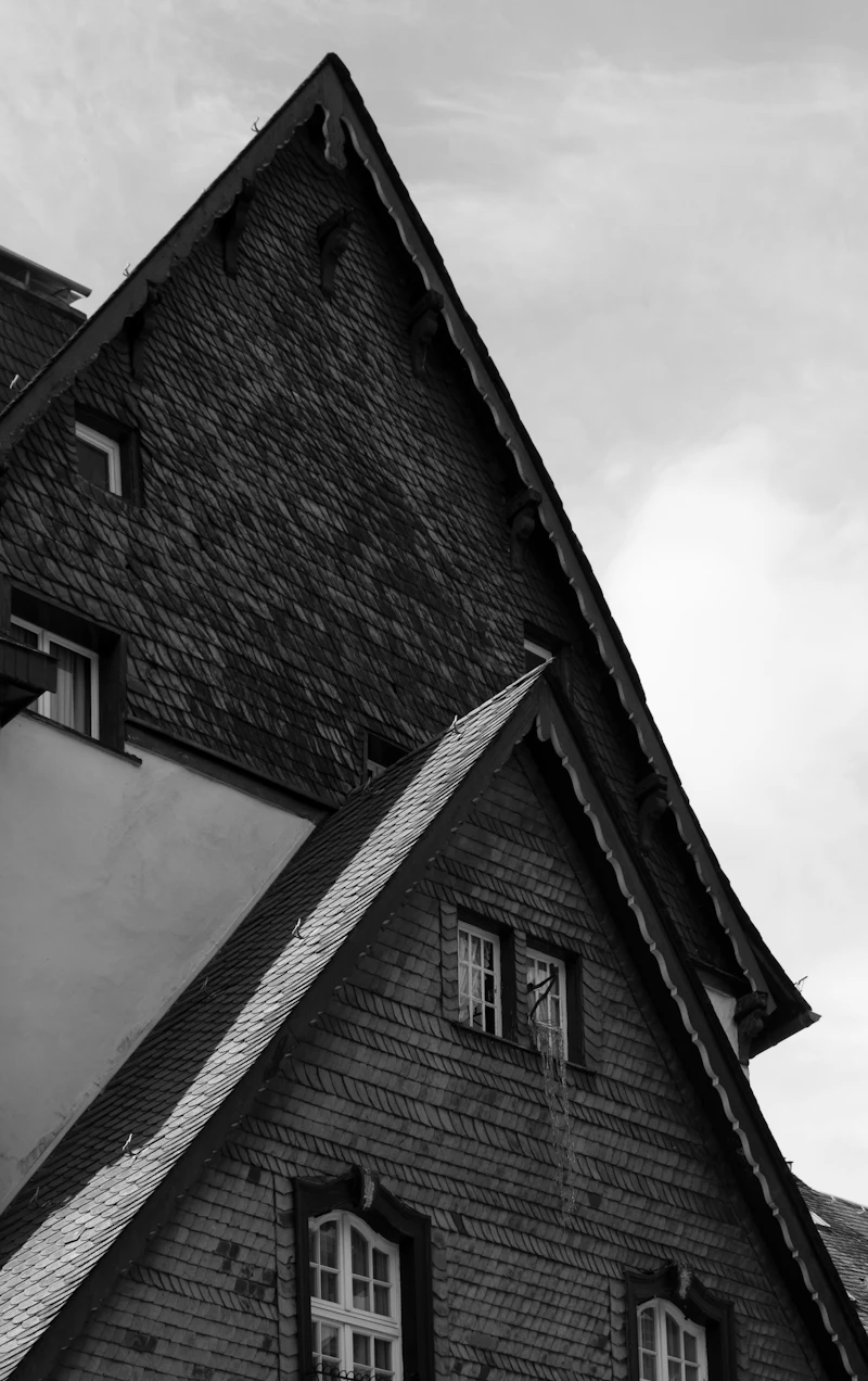 Gable roofs with dark shingles after storm damage repair