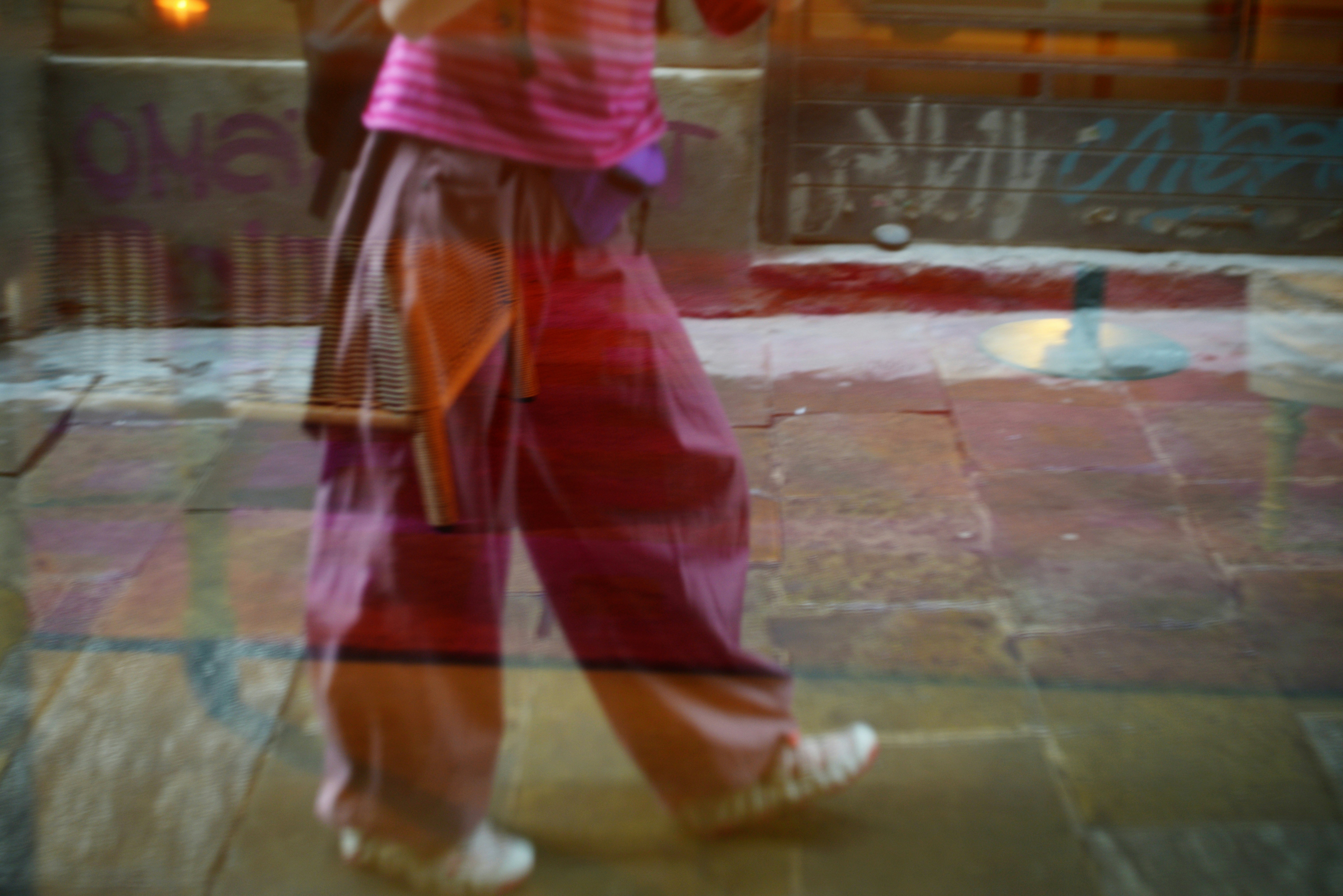 Person walking in loose-fitting pants and white shoes.