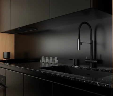 Modern black kitchen counter with sink and faucet.