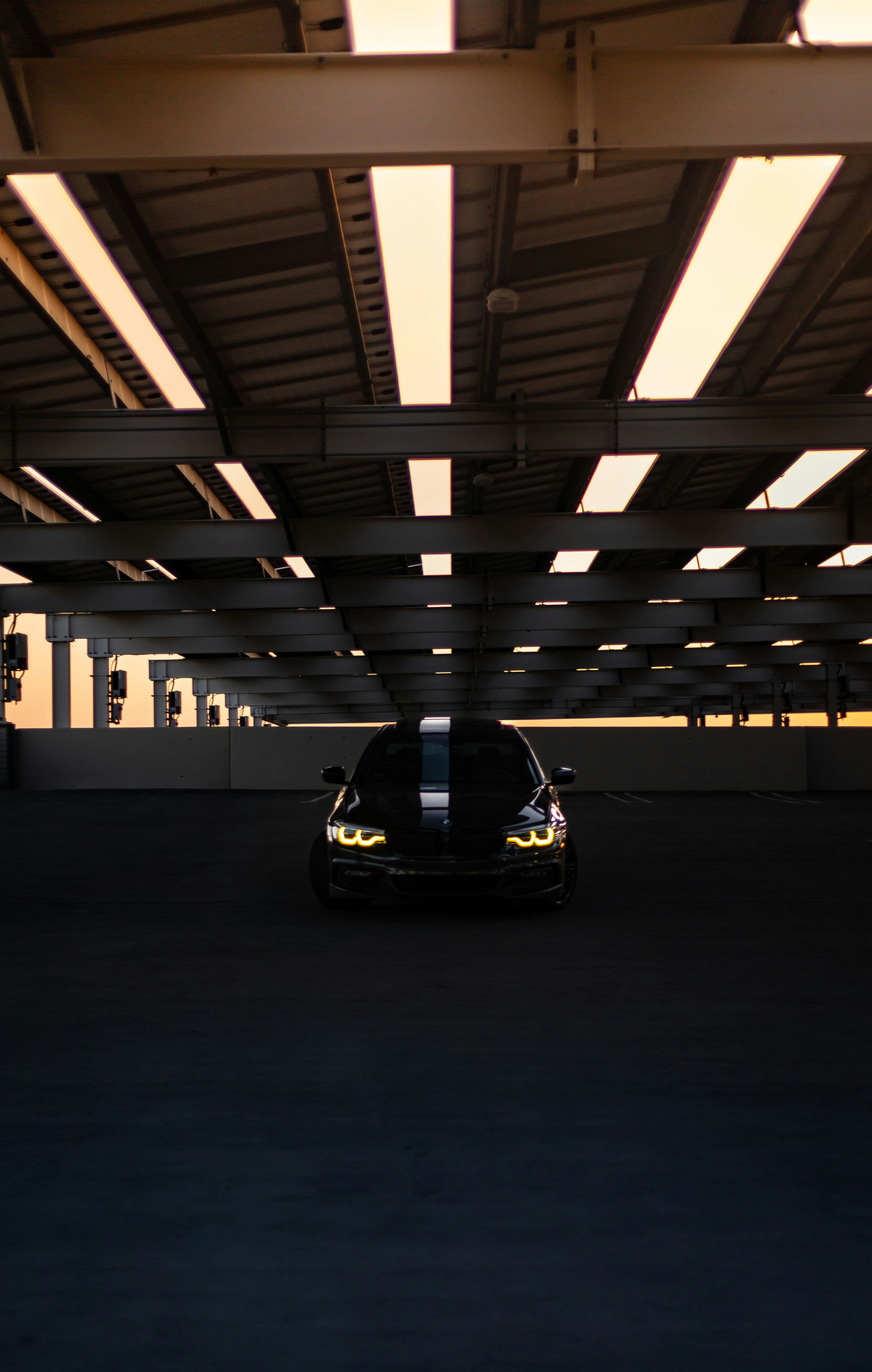 Black car with racing stripes in parking garage