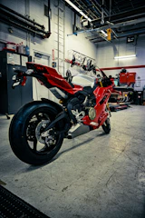 A red sport motorcycle parked in a garage.