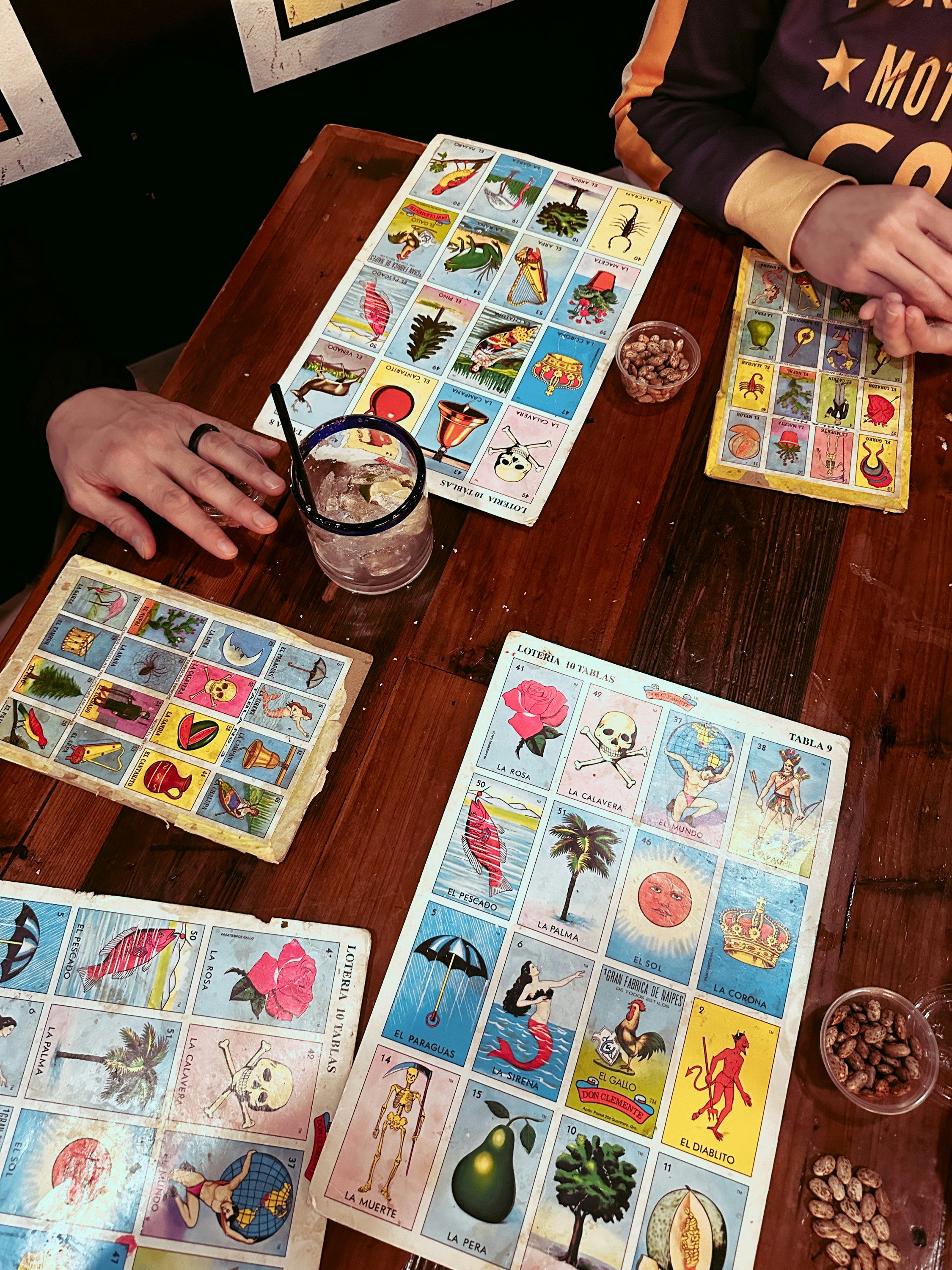 People playing loteria with drinks and snacks.