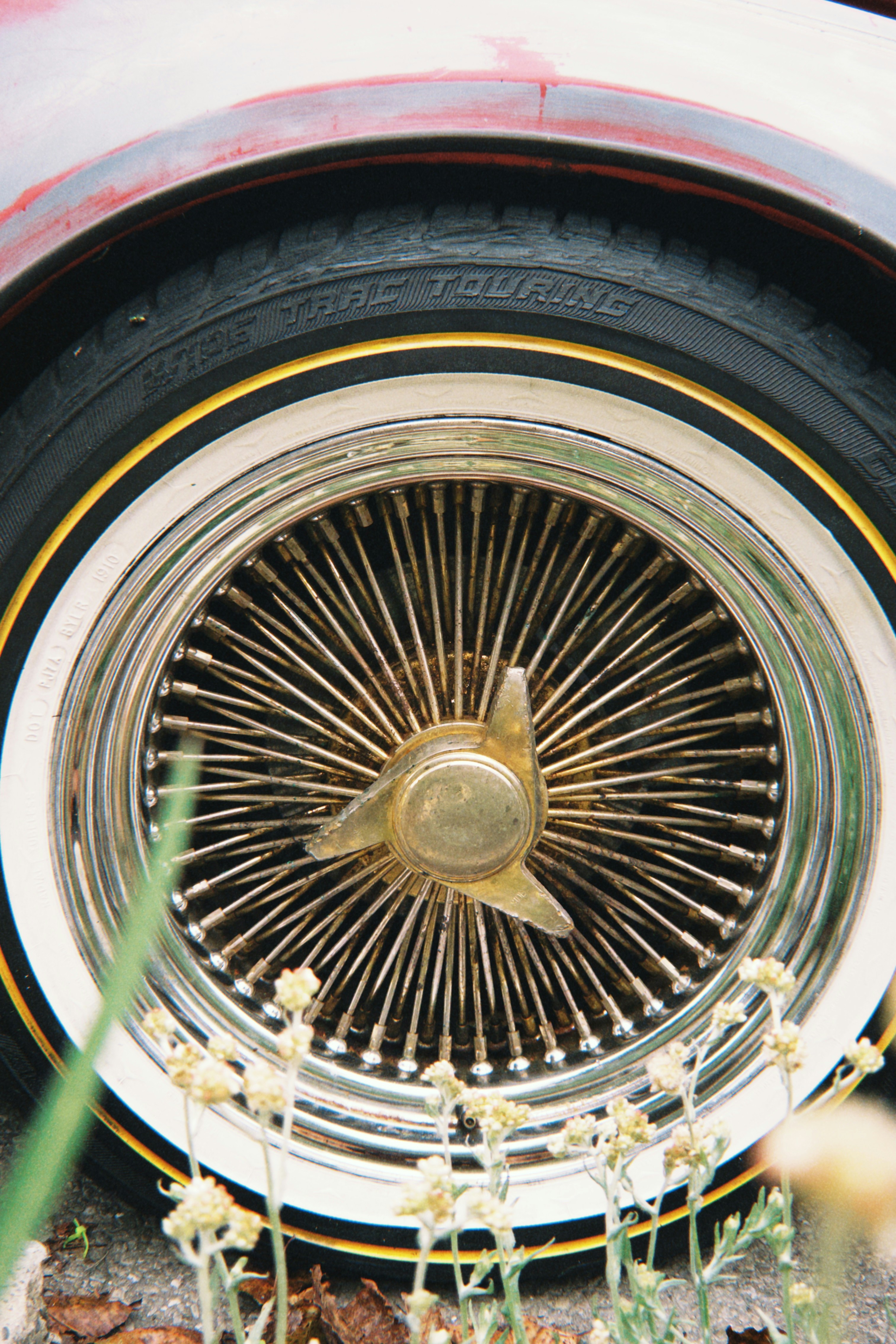 Close-up of a vintage wire wheel on a car.