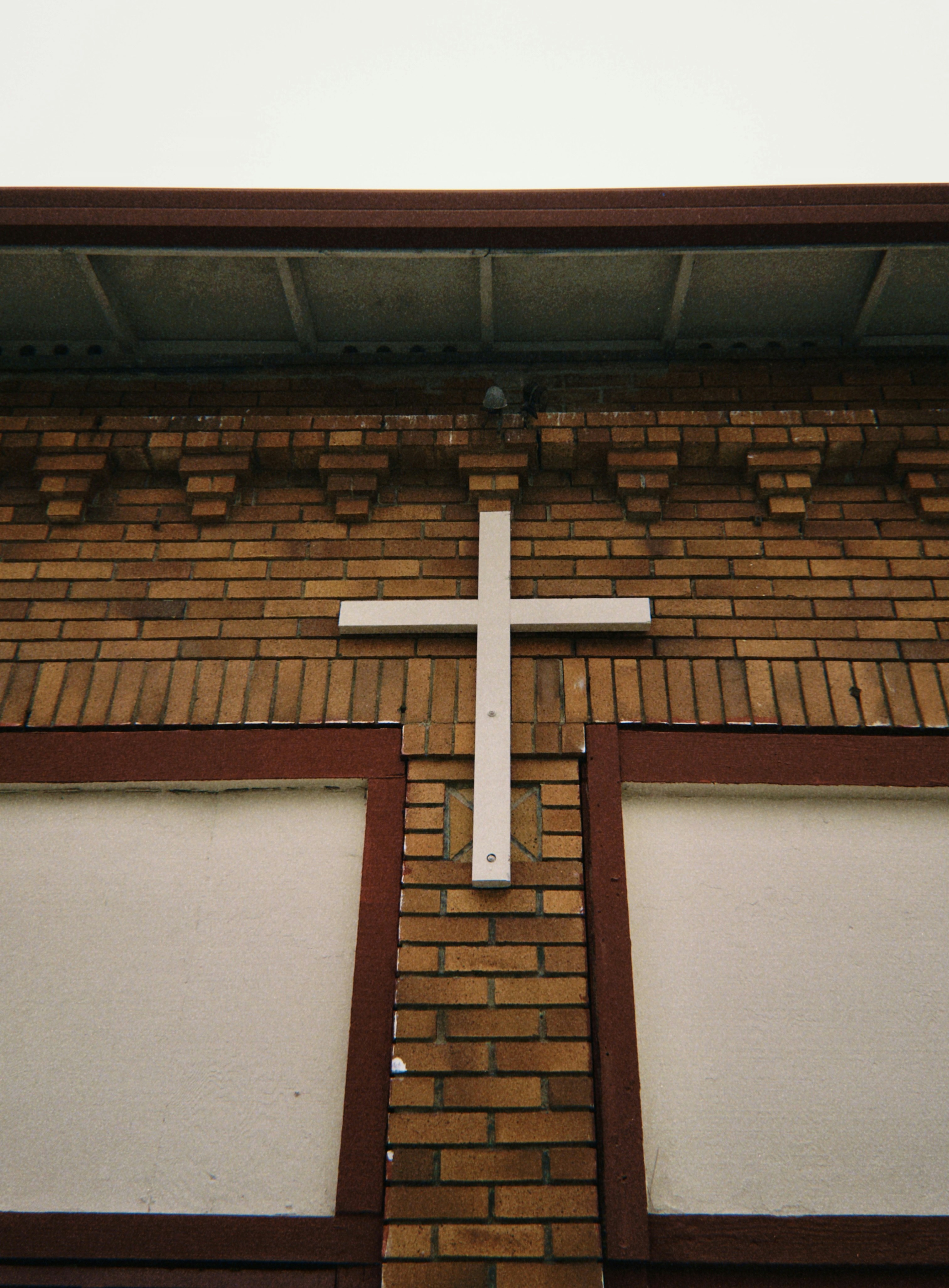 White cross on a brick building exterior