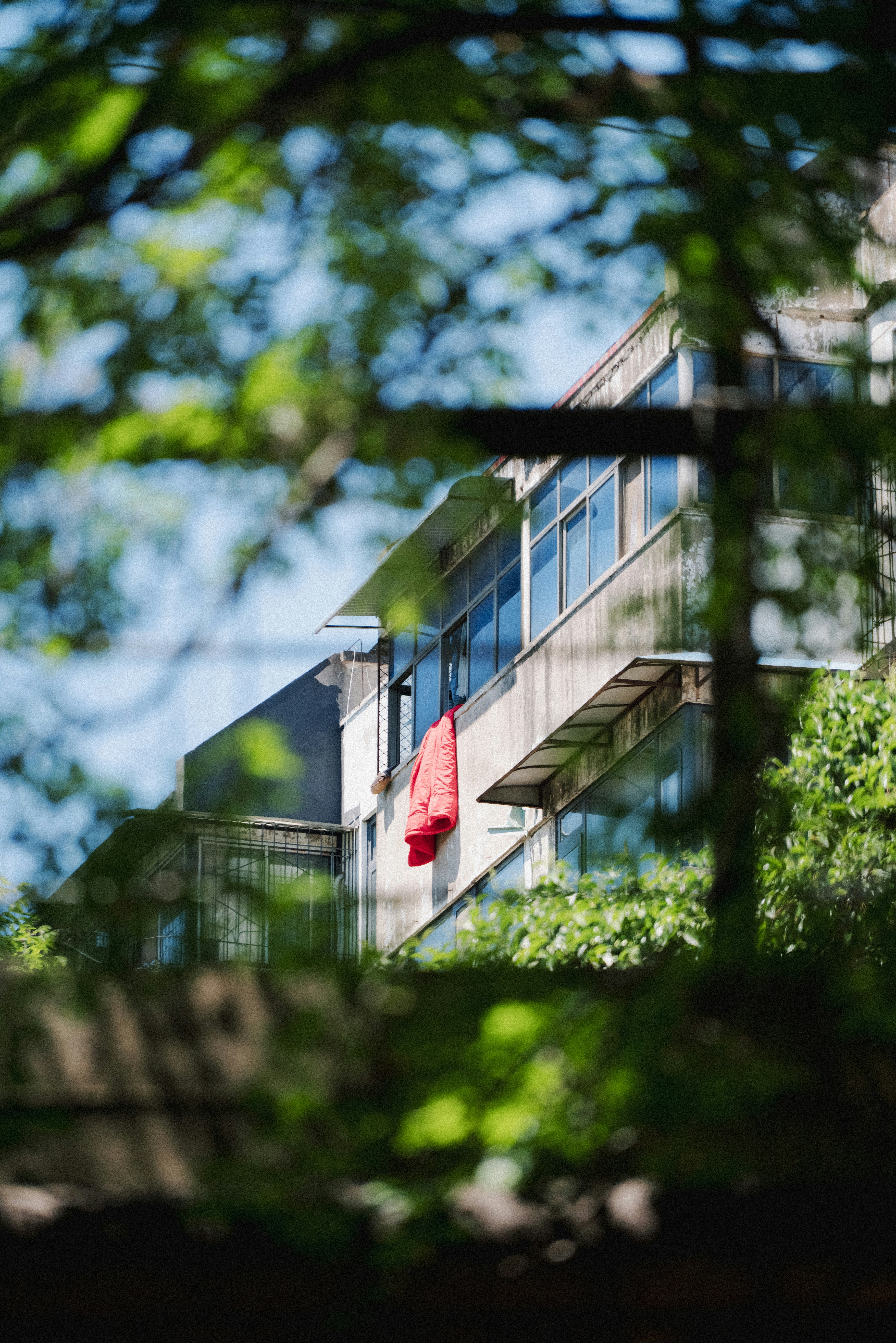 Red jacket hanging on a balcony of a building.