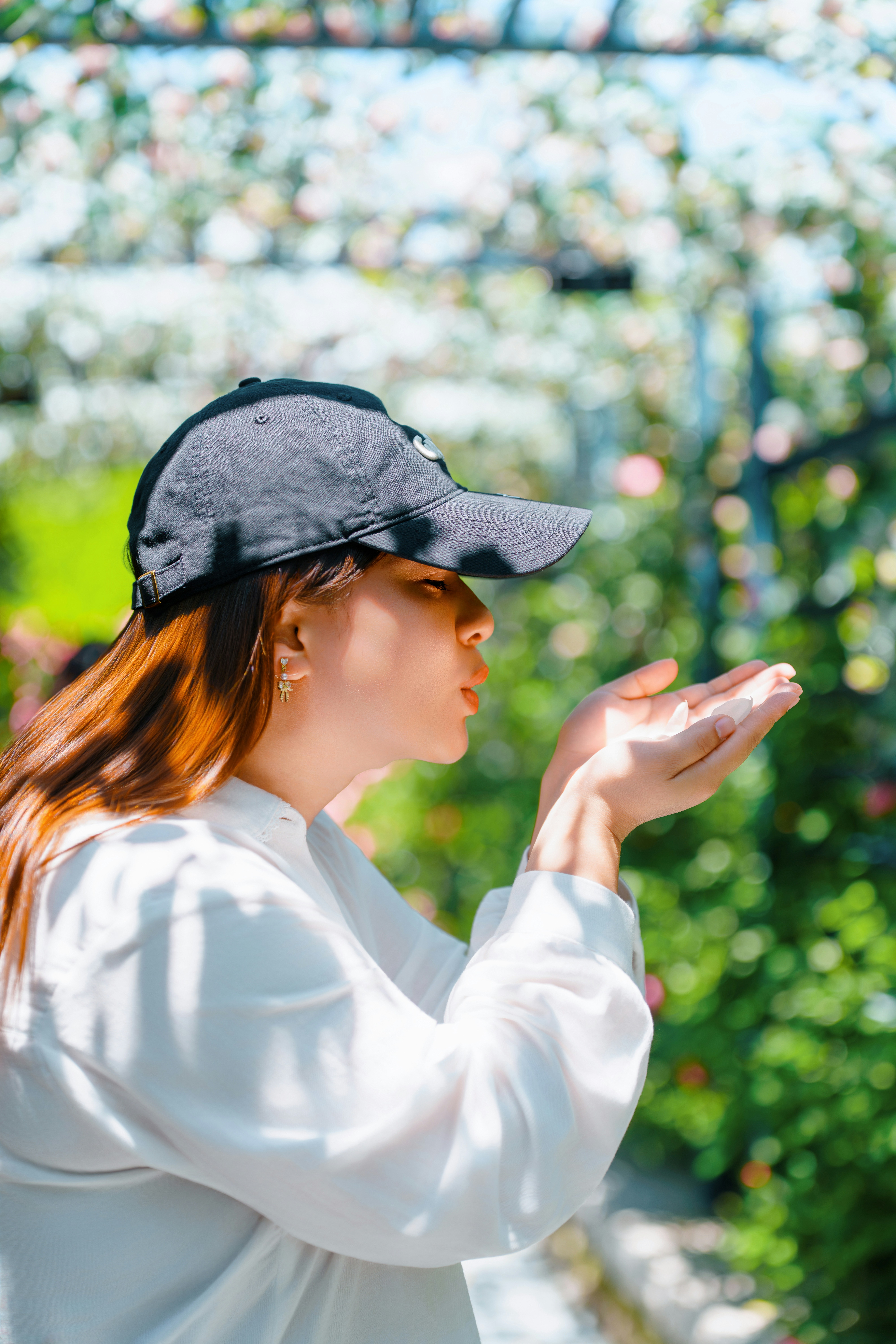 Woman blowing petals in a garden