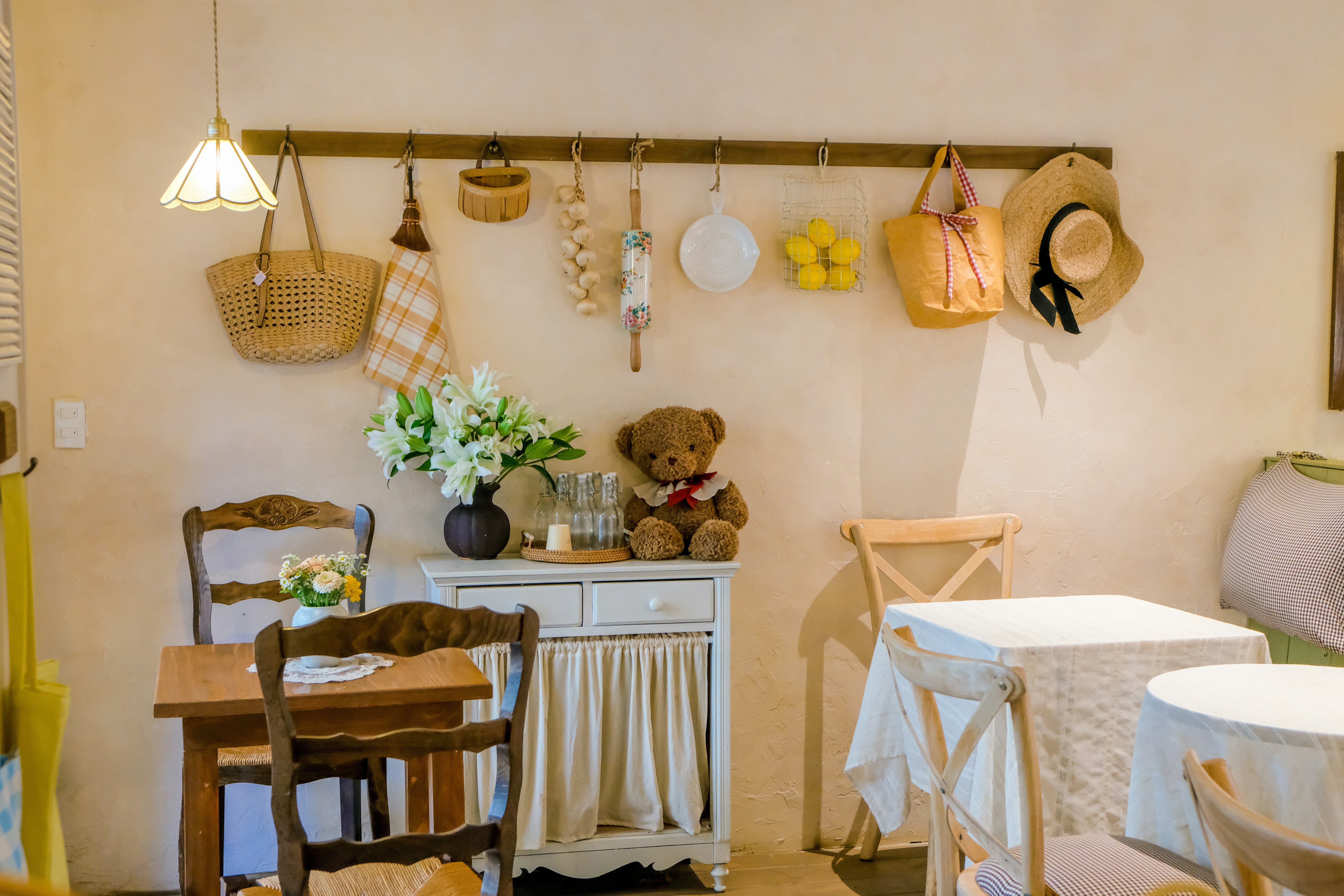 Interior acogedor de café con mesas, sillas y objetos decorativos.