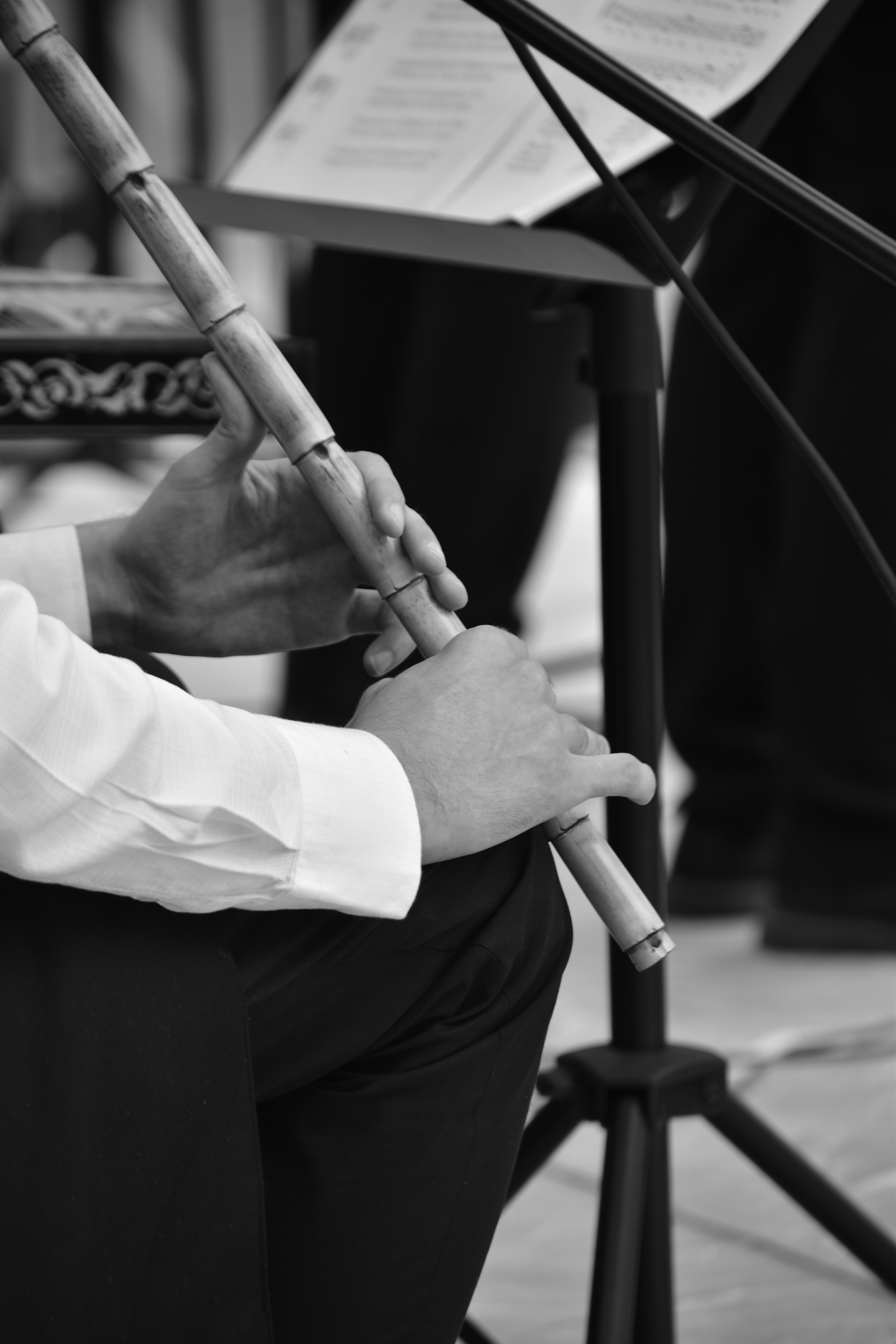Músico tocando flauta de bambu com partitura