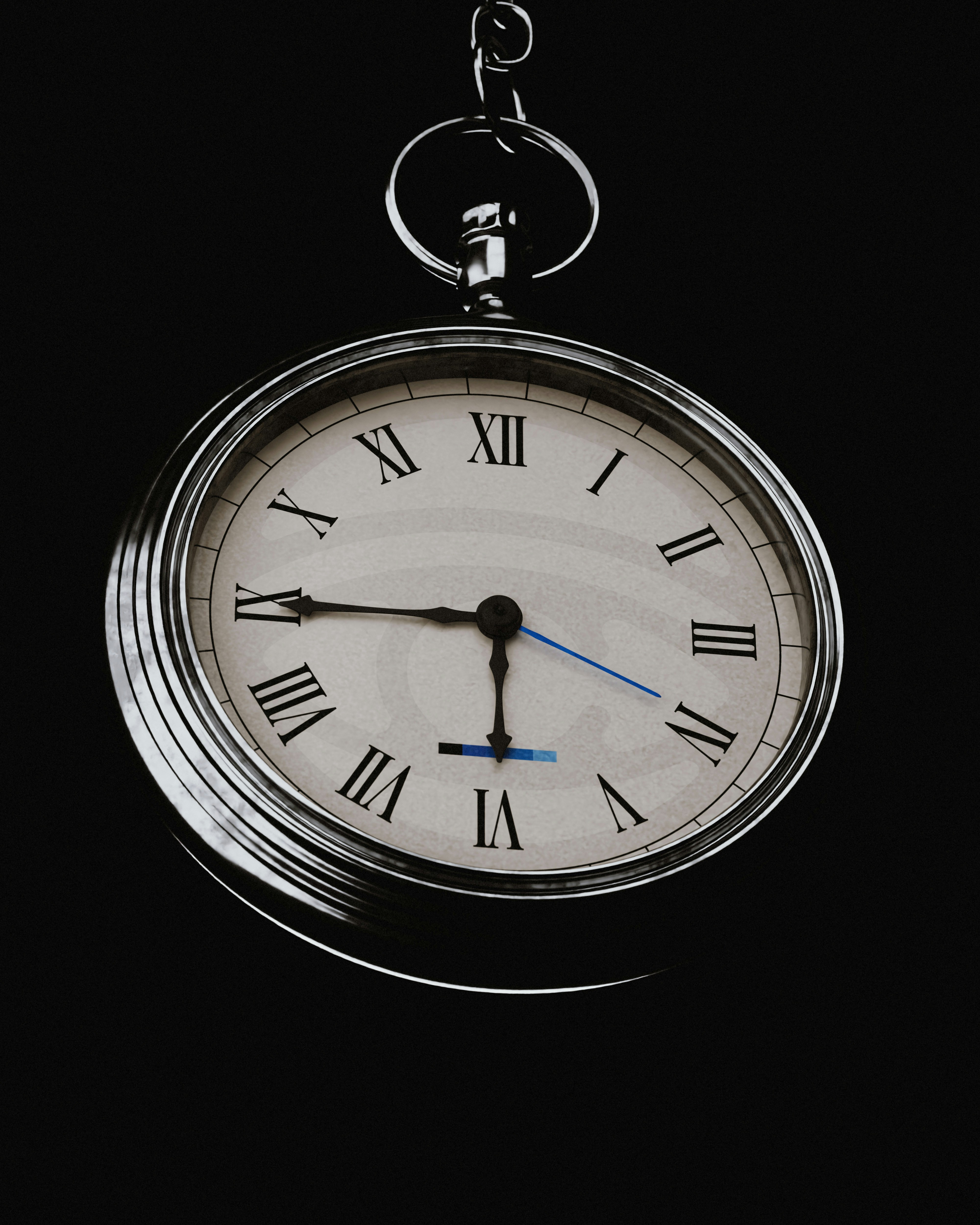 A vintage pocket watch hanging against a black background