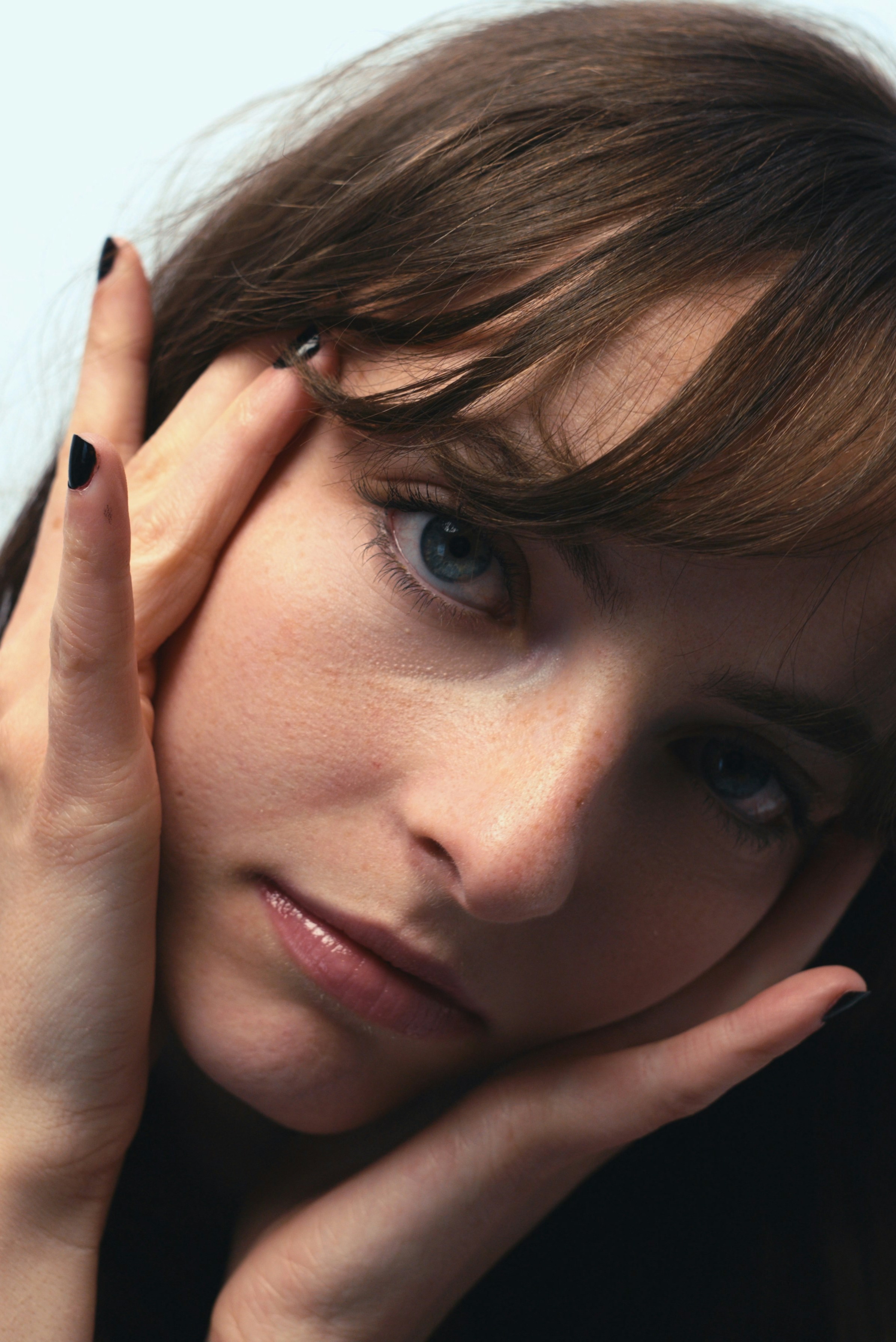 Primo piano del volto di una donna con le mani sulle guance