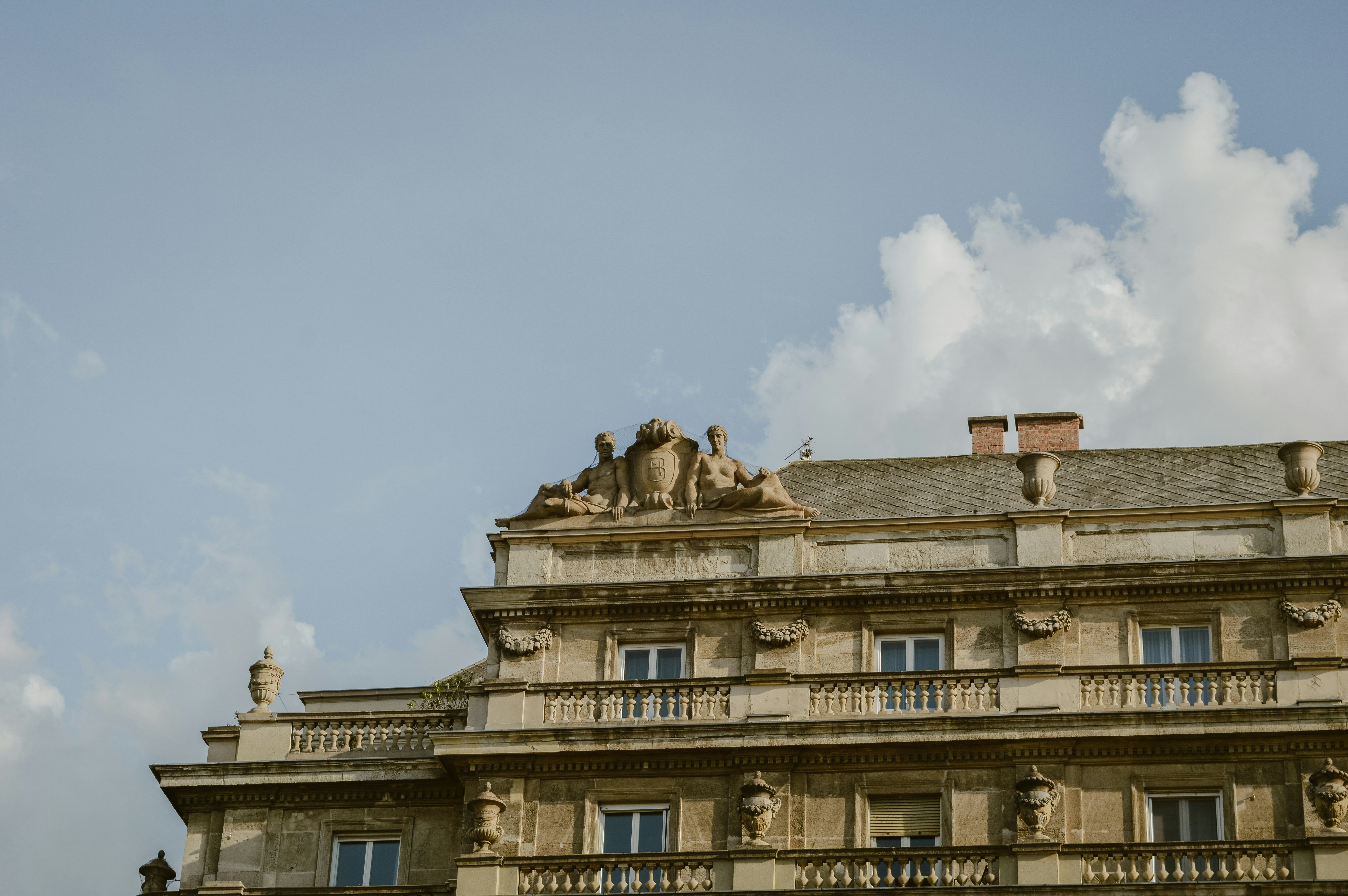 Ornate old building with sculptures against a blue sky.