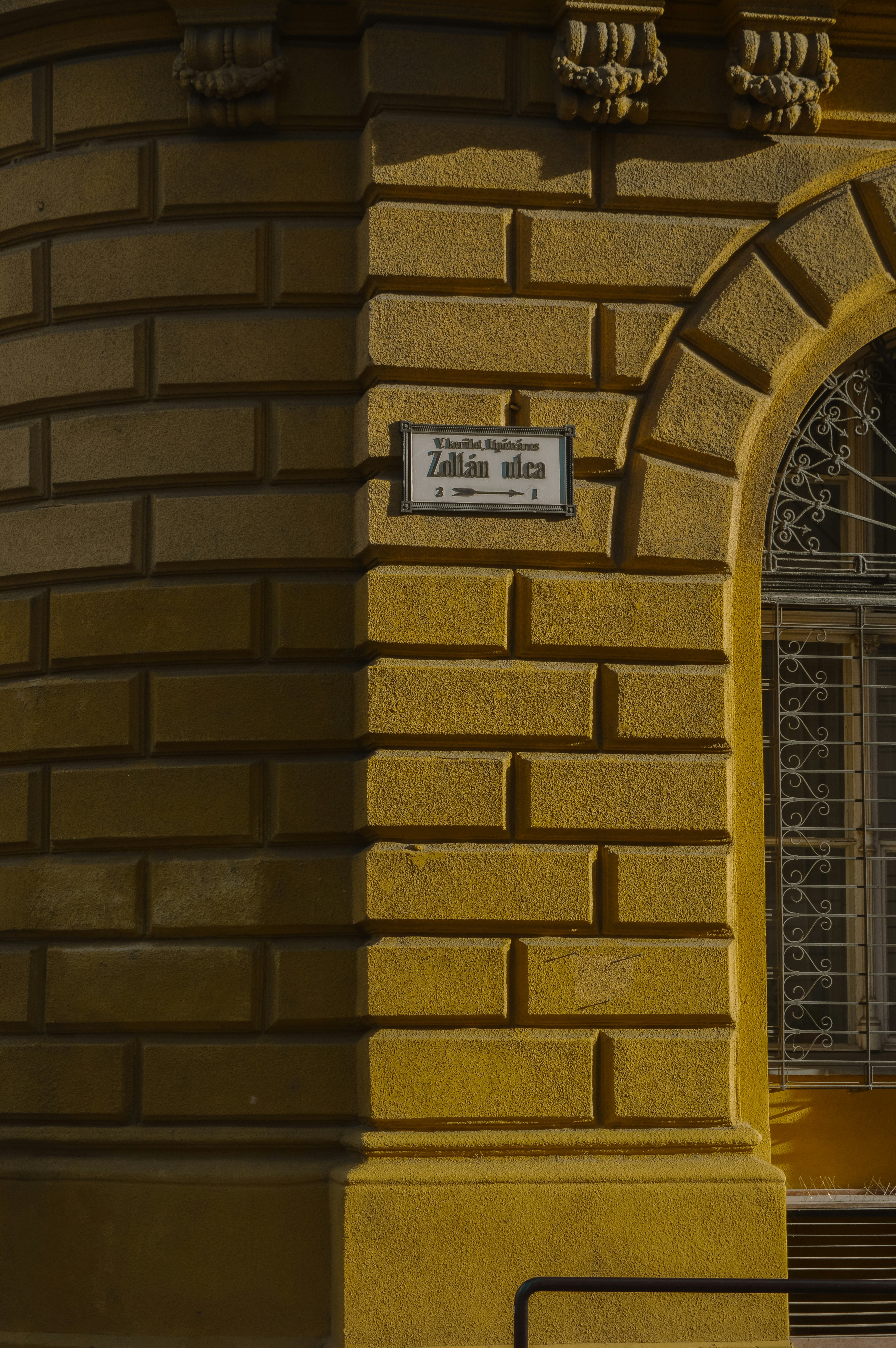 Yellow brick building corner with street sign