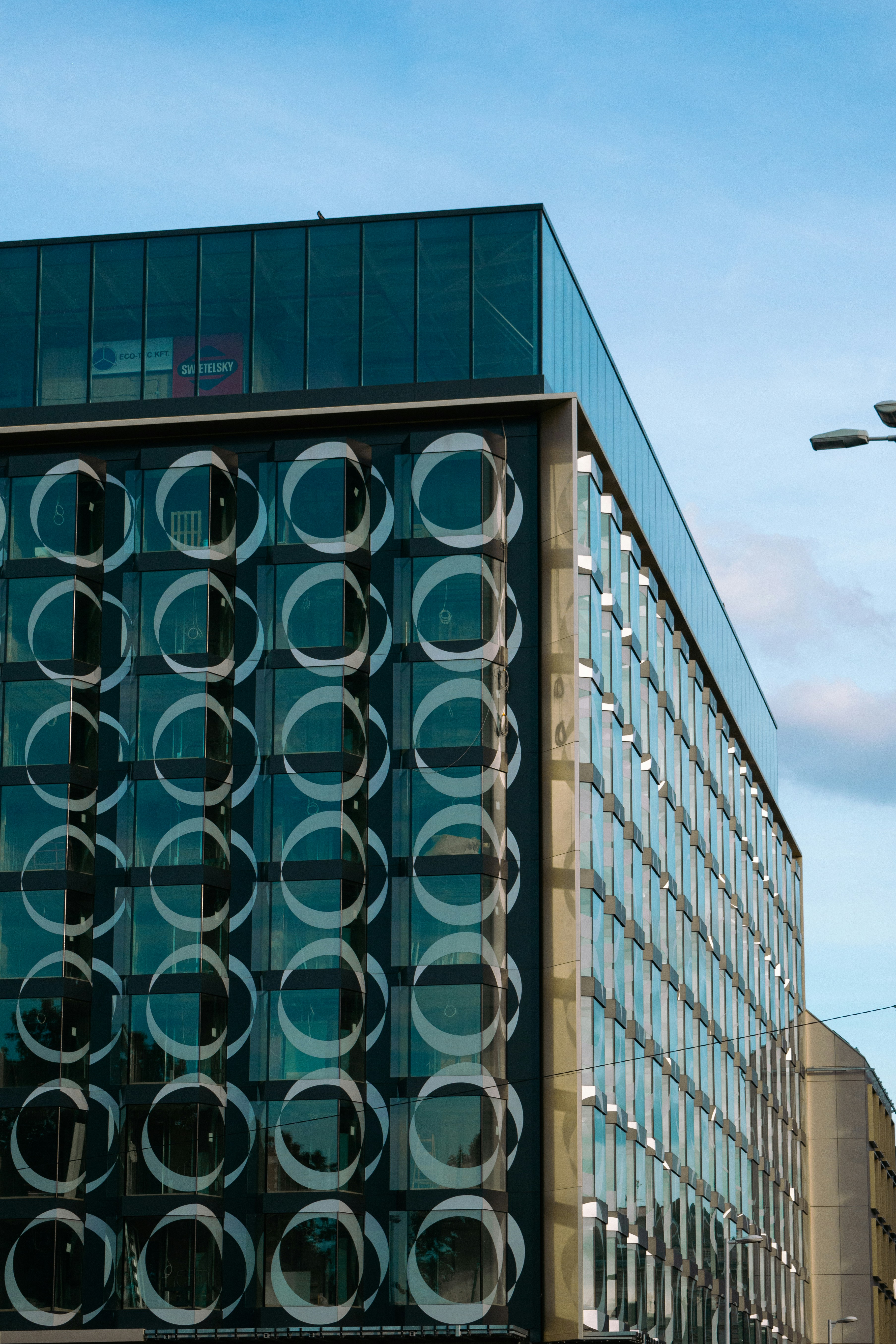 A modern building with a glass facade and circular patterns.