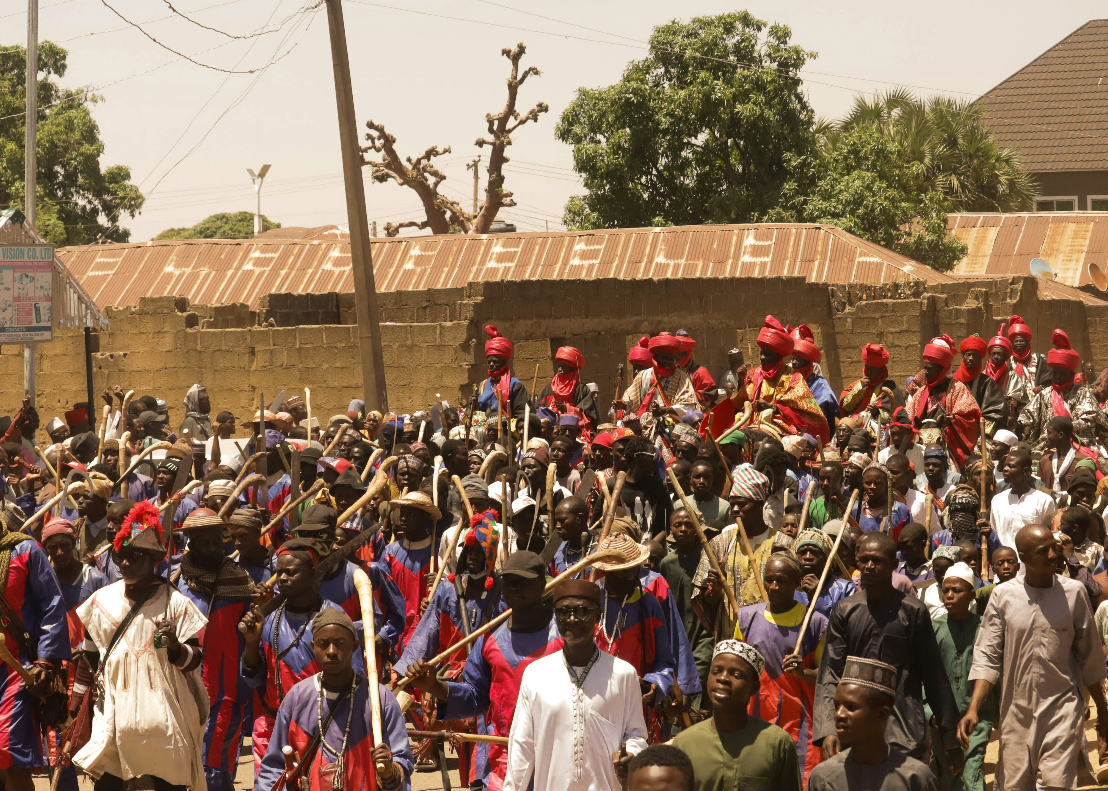 Crowd of people in traditional attire with weapons