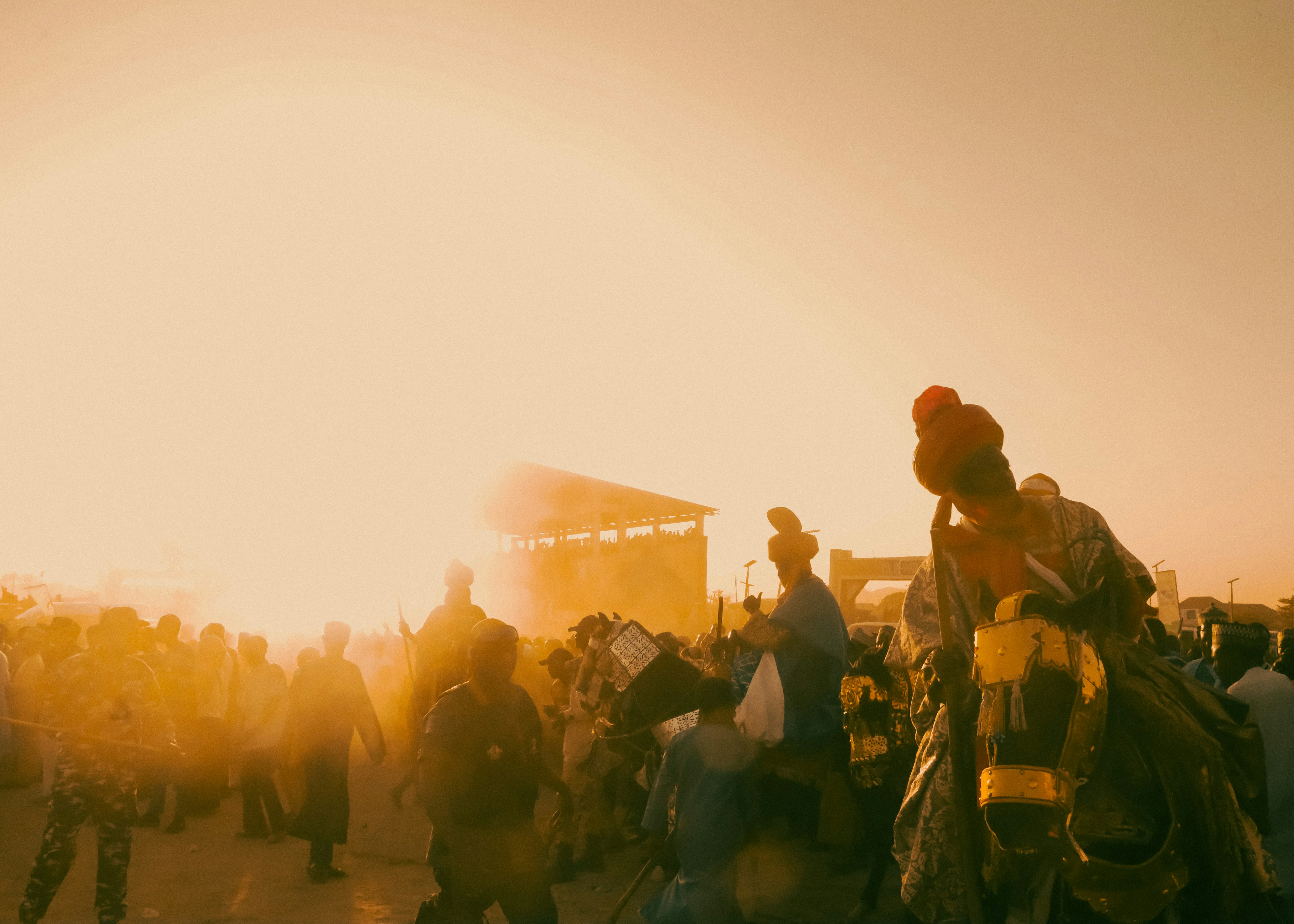 People on horseback in a dusty, sunlit crowd.