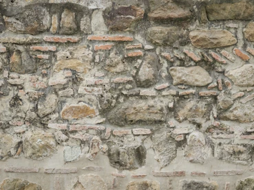 An old weathered wall made of stones and bricks.