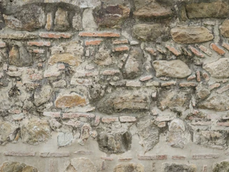 An old weathered wall made of stones and bricks.
